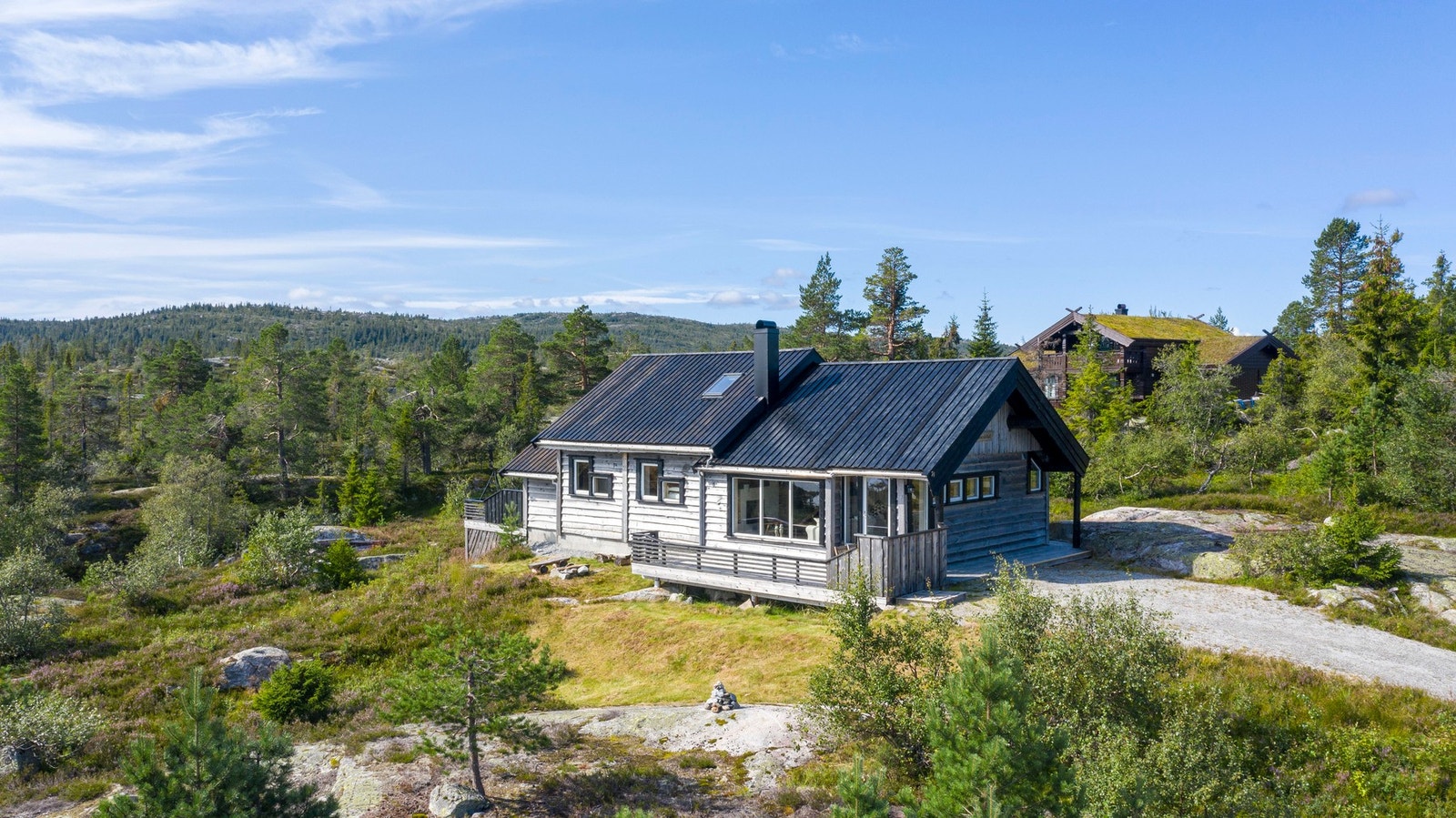 Tradisjonell hytte med flott trekledning og store vindusflater som slipper naturen inn. Galleribilde