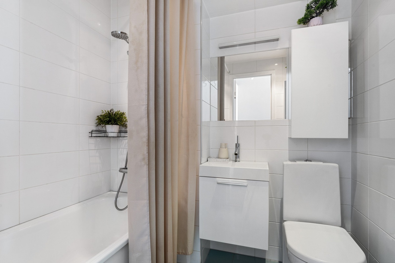 - Badet er innredet med servant med møblement, innfliset speil med belysning, høyskap, overskap, toalett, dusjgarnityr og badekar, noe som gjør badet praktisk tilpasset ulike behov i hverdagen - Galleribilde