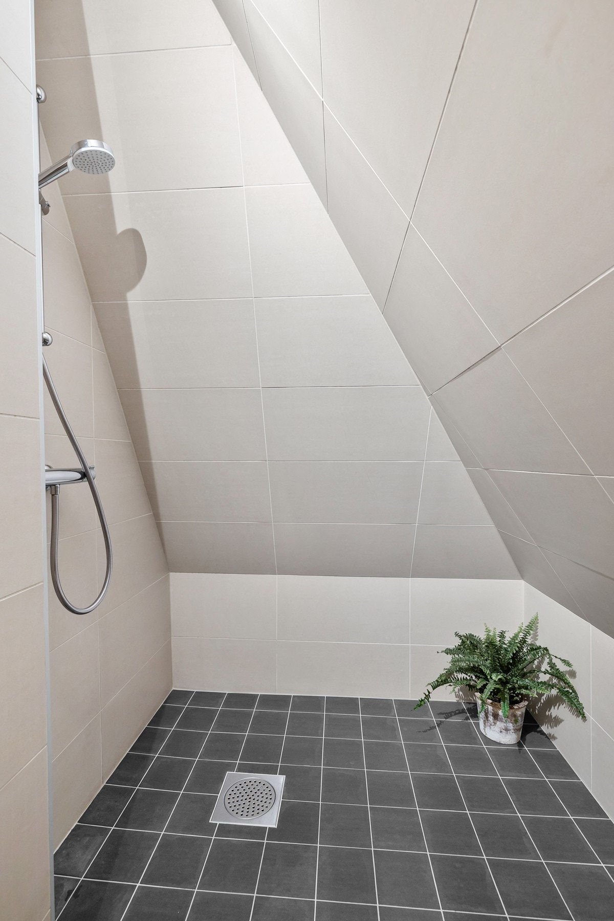 Badet er bl.a. utstyrt med et dusjhjørne med vegghengt dusjarmatur Galleribilde