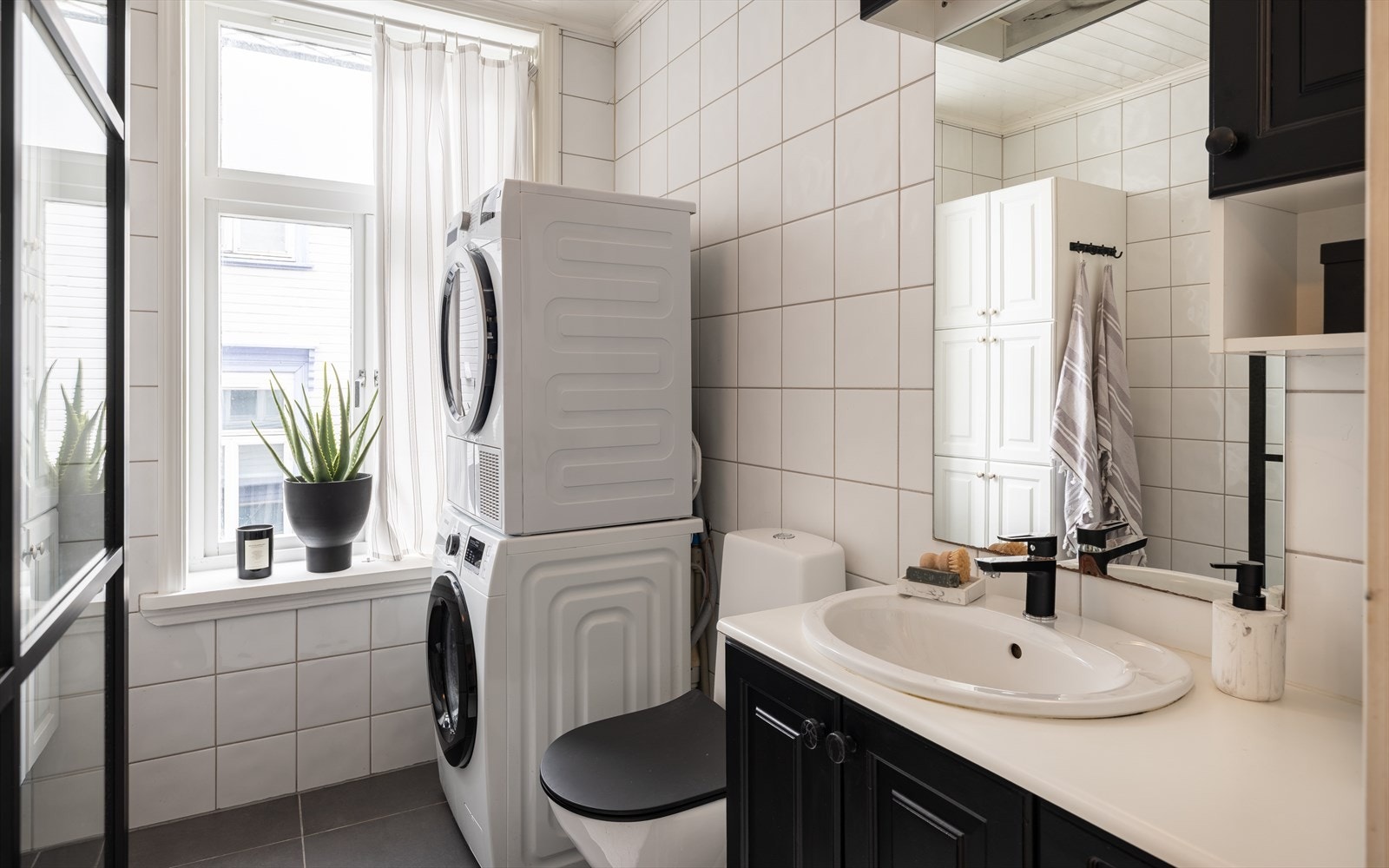 Baderommet har varmekabler i gulv. Utstyrt med dusjhjørne, gulvmontert WC, baderomsinnredning med underskap, speil, veggskap og høyskap. Kran og avløp for vaskemaskin. Galleribilde