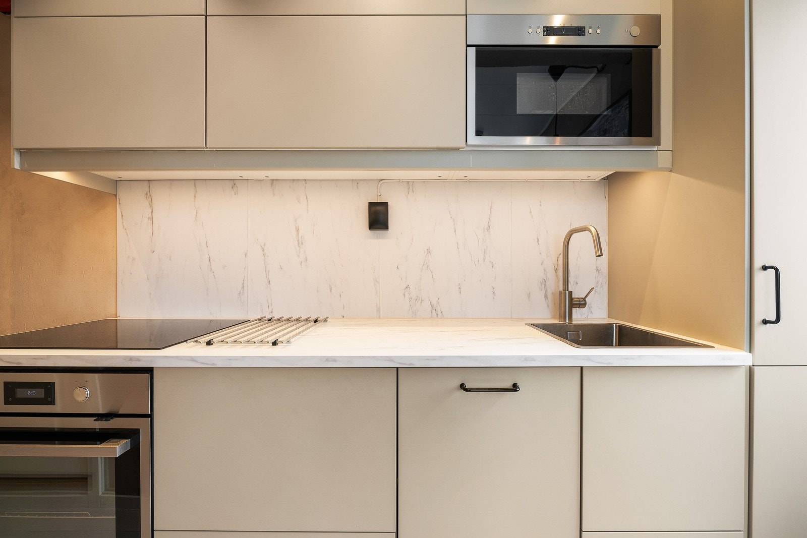 Lekker backsplash i marmorerte farger, samt laminat benkeplate med nedfelt vask. Her har du godt med skap- og skuffeplass. Galleribilde