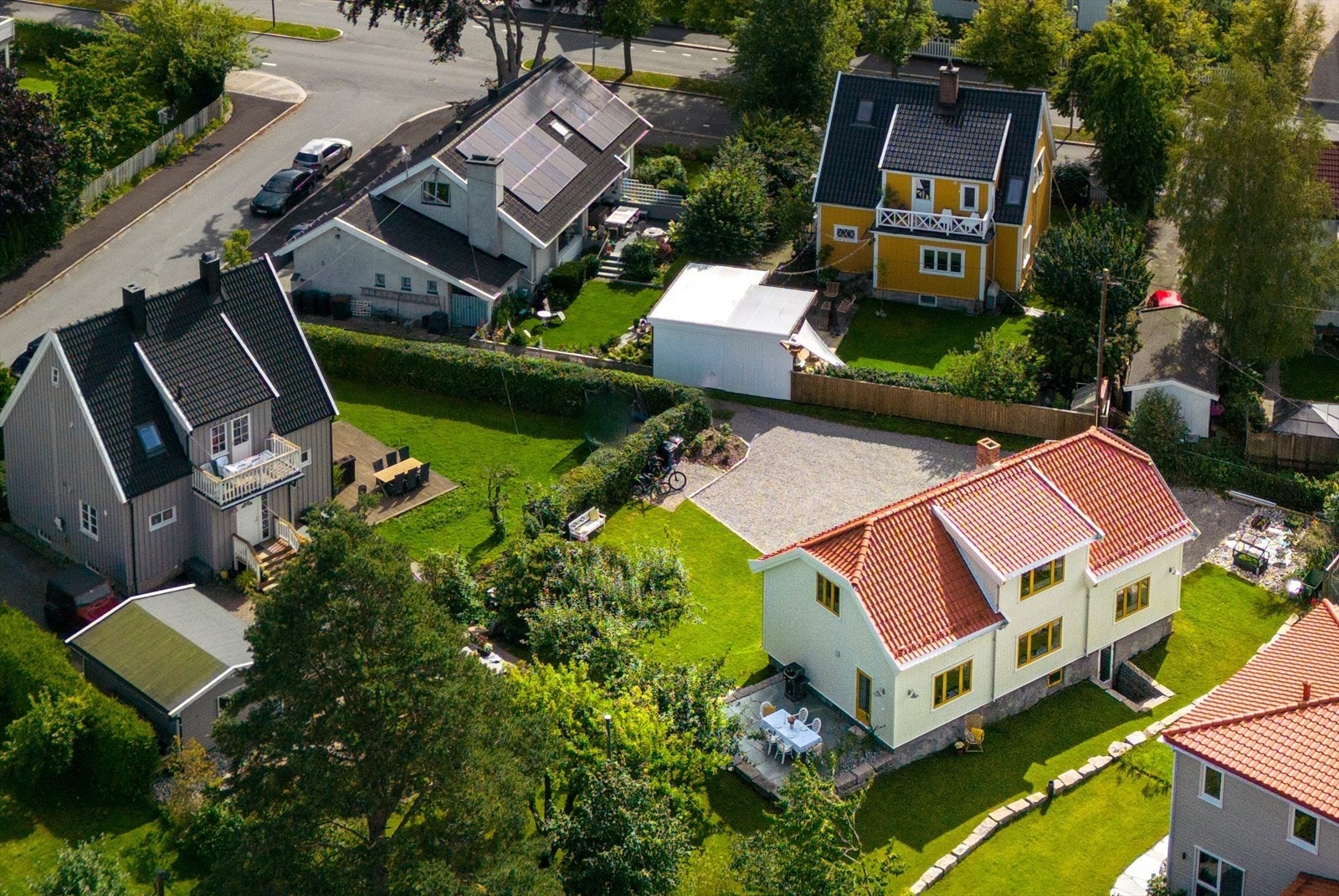 Fra veien følger man innkjørselen inn i hjertet av kvartalet, lengst mulig vekk fra trafikken. Bak en stor, velordnet gårdsplass med singel, hviler den renoverte og eksklusive villaen. Foto: Eivind Lauritzen Galleribilde
