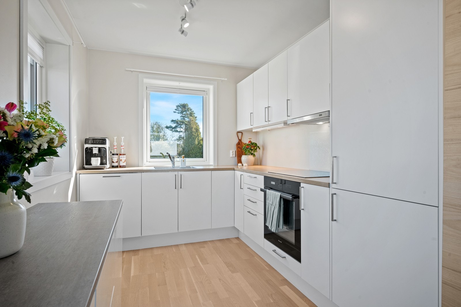 Kjøkkenet har innredning med glatte fronter. Benkeplaten er av laminat. Det er integrert kjøl/fryseskap, oppvaskmaskin, induksjonstopp og stekeovn Galleribilde