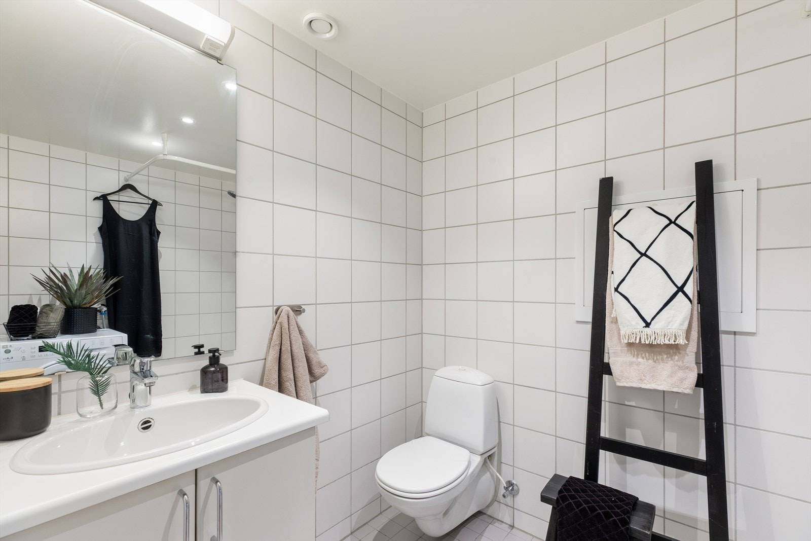 Badet er helfliset med hvite fliser på både gulv og vegger, og har elektriske varmekabler som gir god komfort Galleribilde