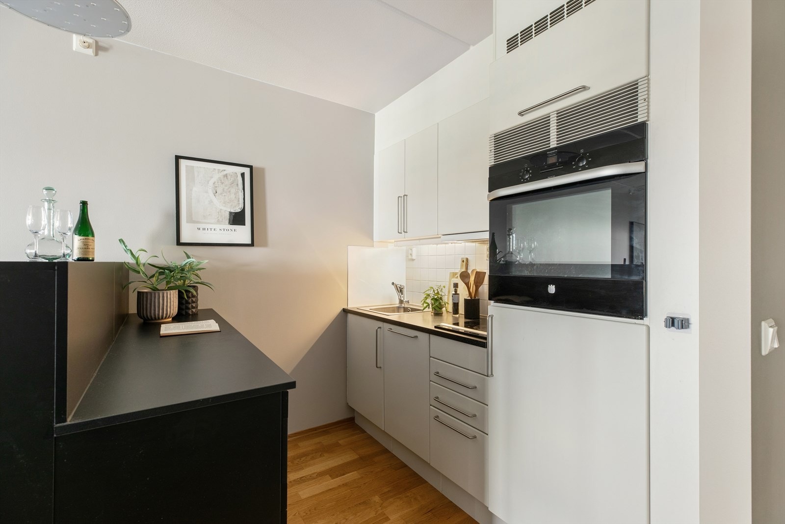 Kjøkkenet har innredningen med glatte fronter, kombinert med laminat benkeplate, oppvaskkum med ettgreps blandebatteri og ventilator over kokesonen Galleribilde