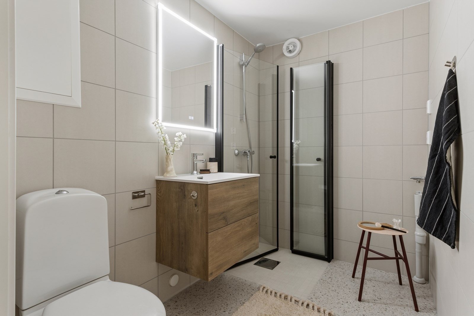 Badet er flislagt med lyse, delikate fliser Galleribilde