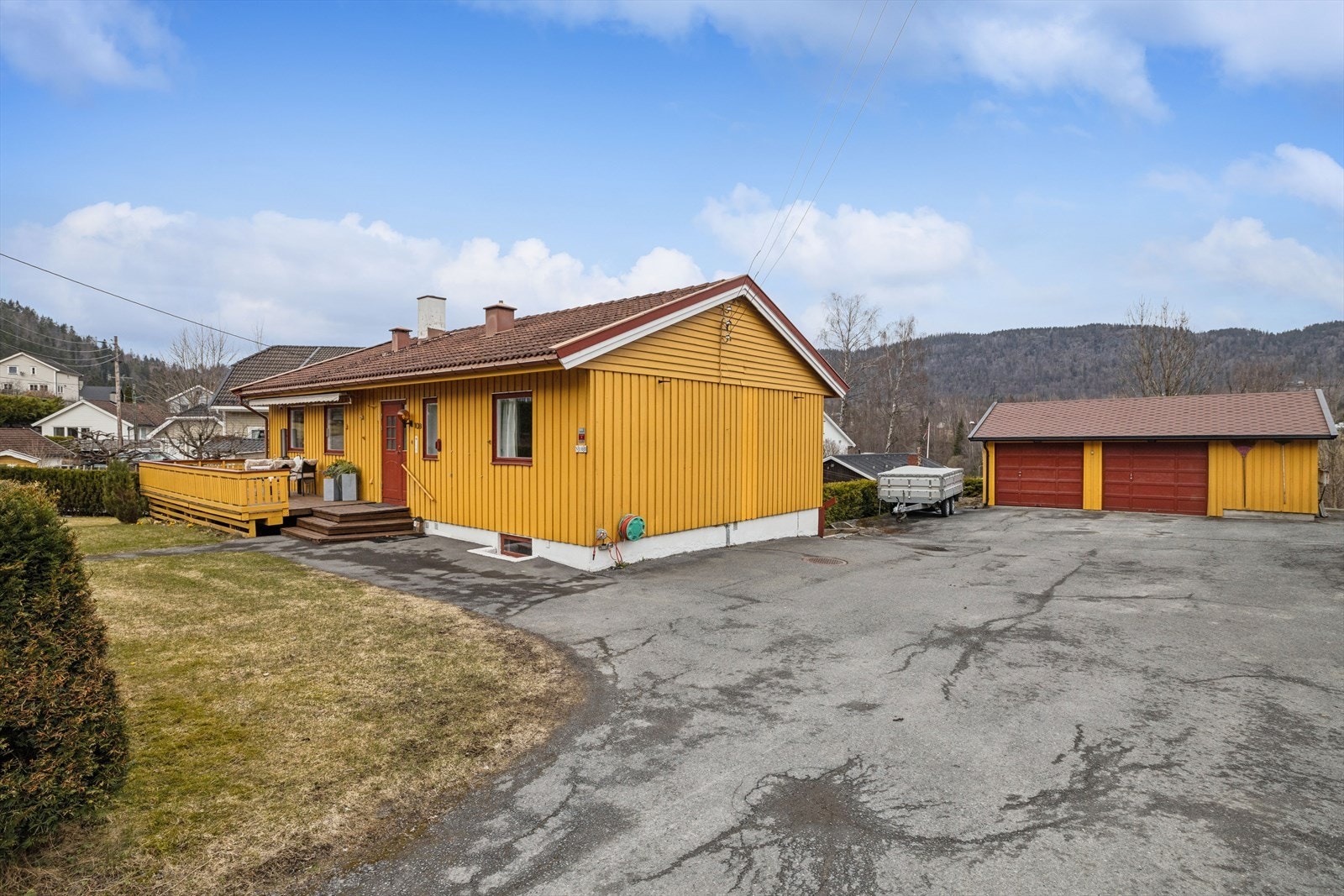 Eiendommen har en stor, asfaltert gårdsplass og en dobbelgarasje på 42 m² fra 1986, som gir rikelig med parkering. Galleribilde