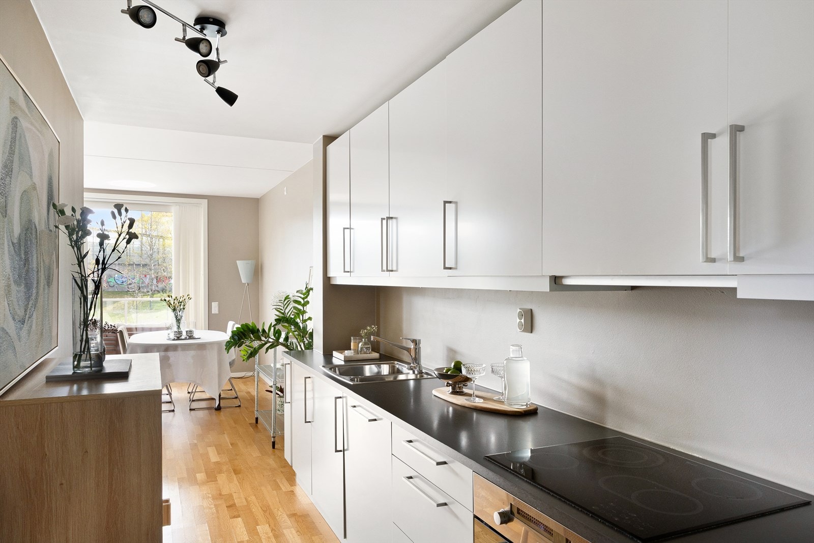 Innredningen har hvite, glatte fronter og laminat benkeplate med nedfelt oppvaskkum, utstyrt med ettgreps svingbart blandebatteri. Galleribilde