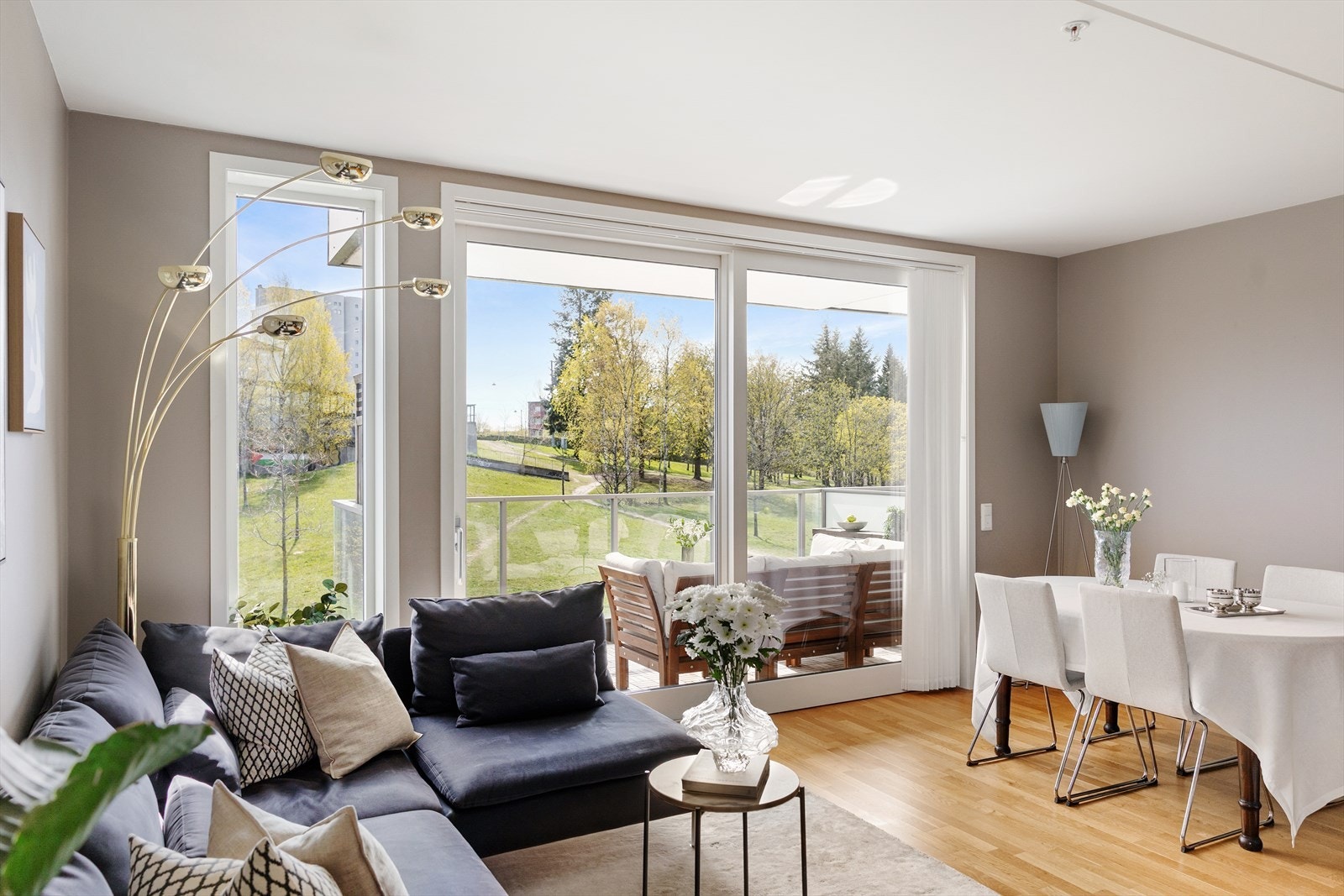 Stuen fremstår som lys, lun og innbydende, med store gulv-til-tak-vinduer som slipper inn rikelig med naturlig lys og gir en nydelig utsikt mot parken. Galleribilde