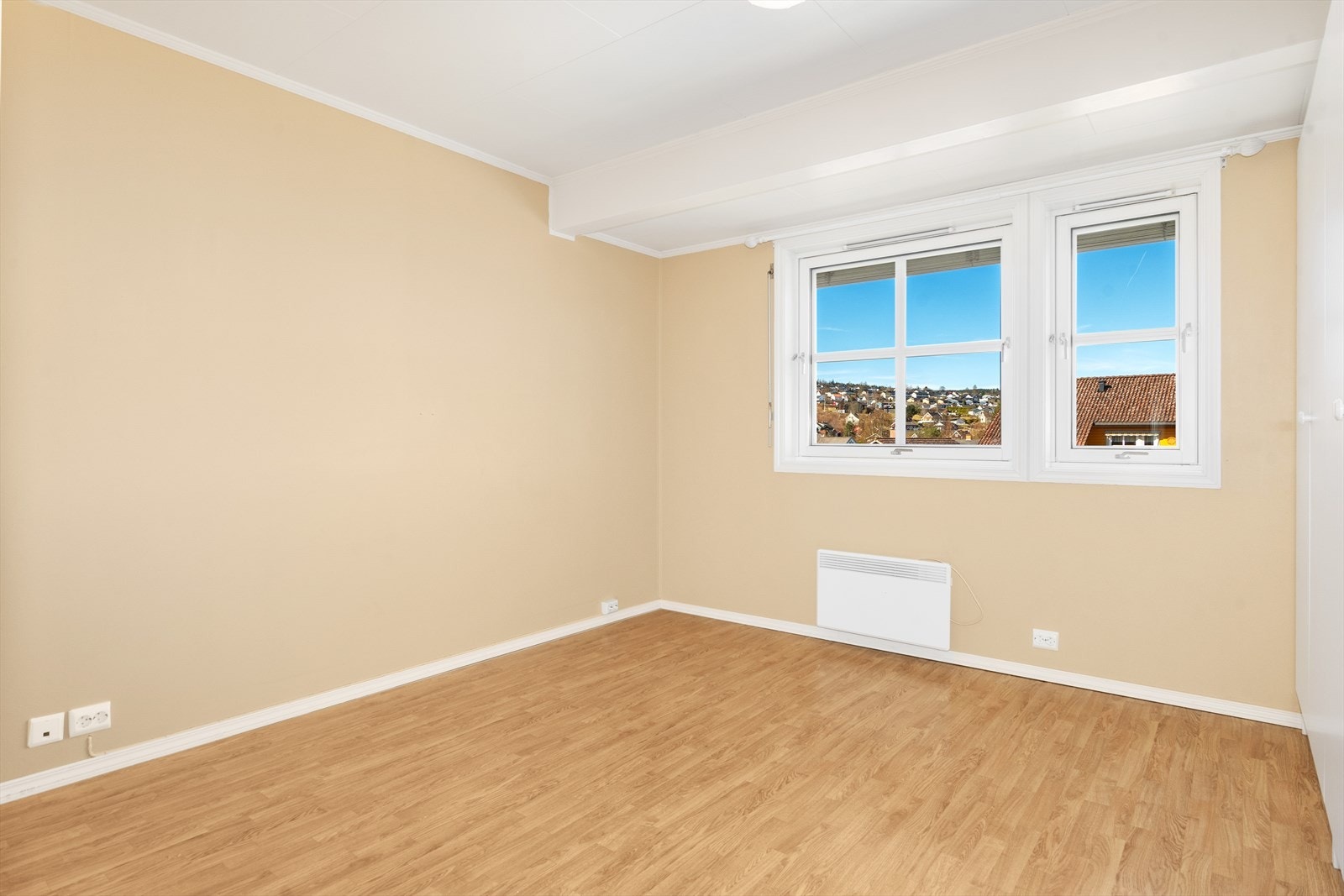 Vegg i vegg med badet ligger det største soverommet som er malt i en behagelige beige farge. Galleribilde