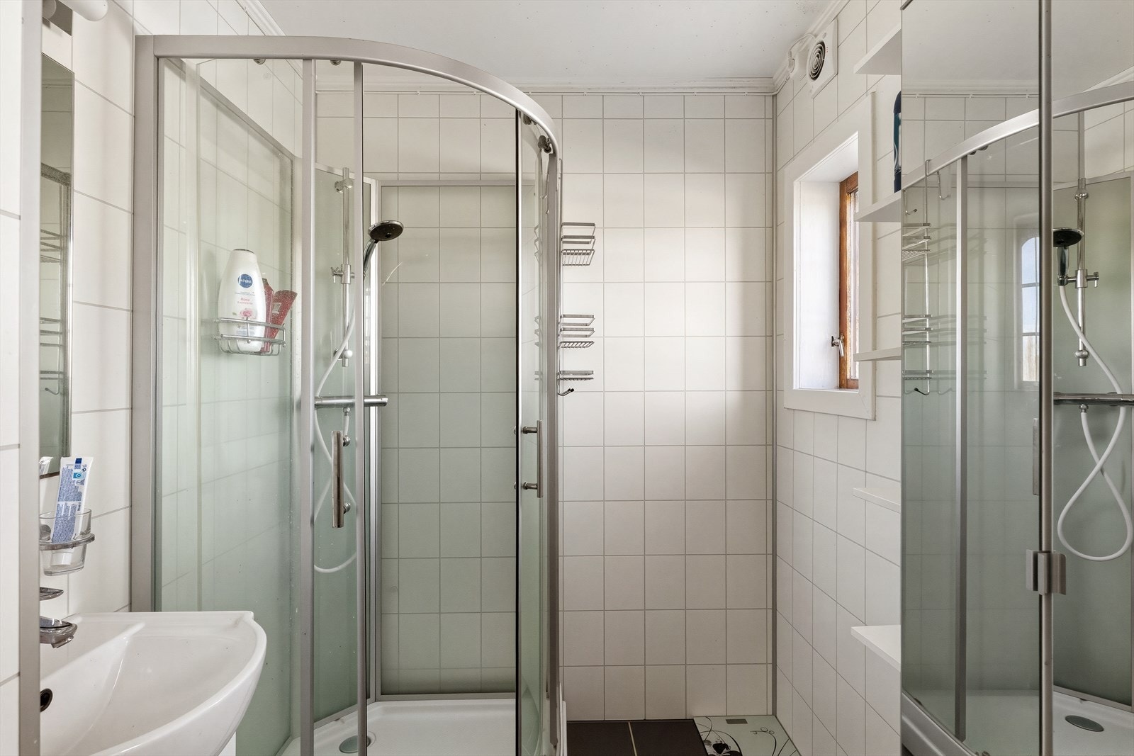 Badet er utstyrt med dusjkabinett, servantseksjon og varmekabler i gulvet. Galleribilde