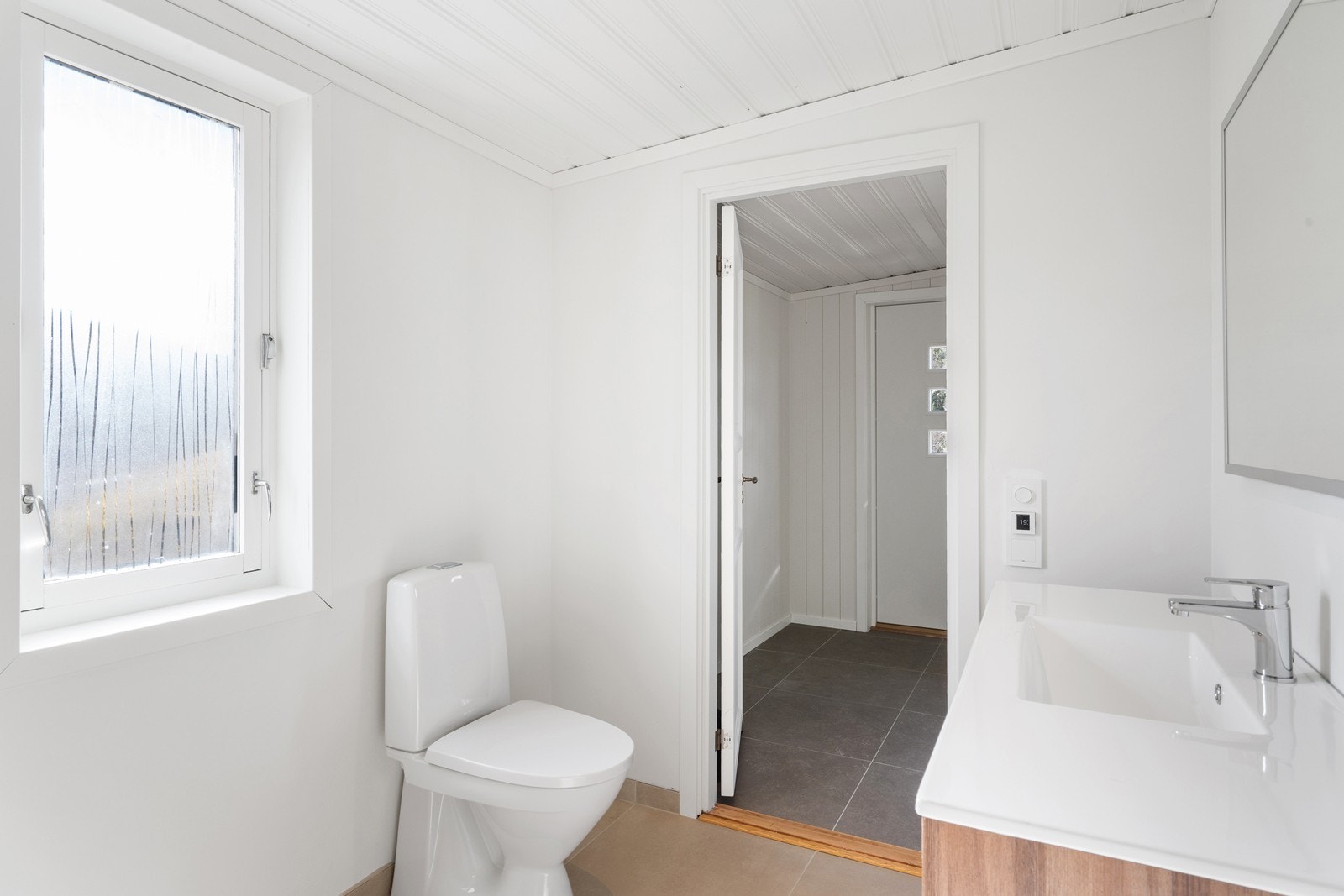 Badet er innredet med servant, gulvfestet toalett og dusjhjørne. Det er også opplegg for vaskemaskin. Galleribilde