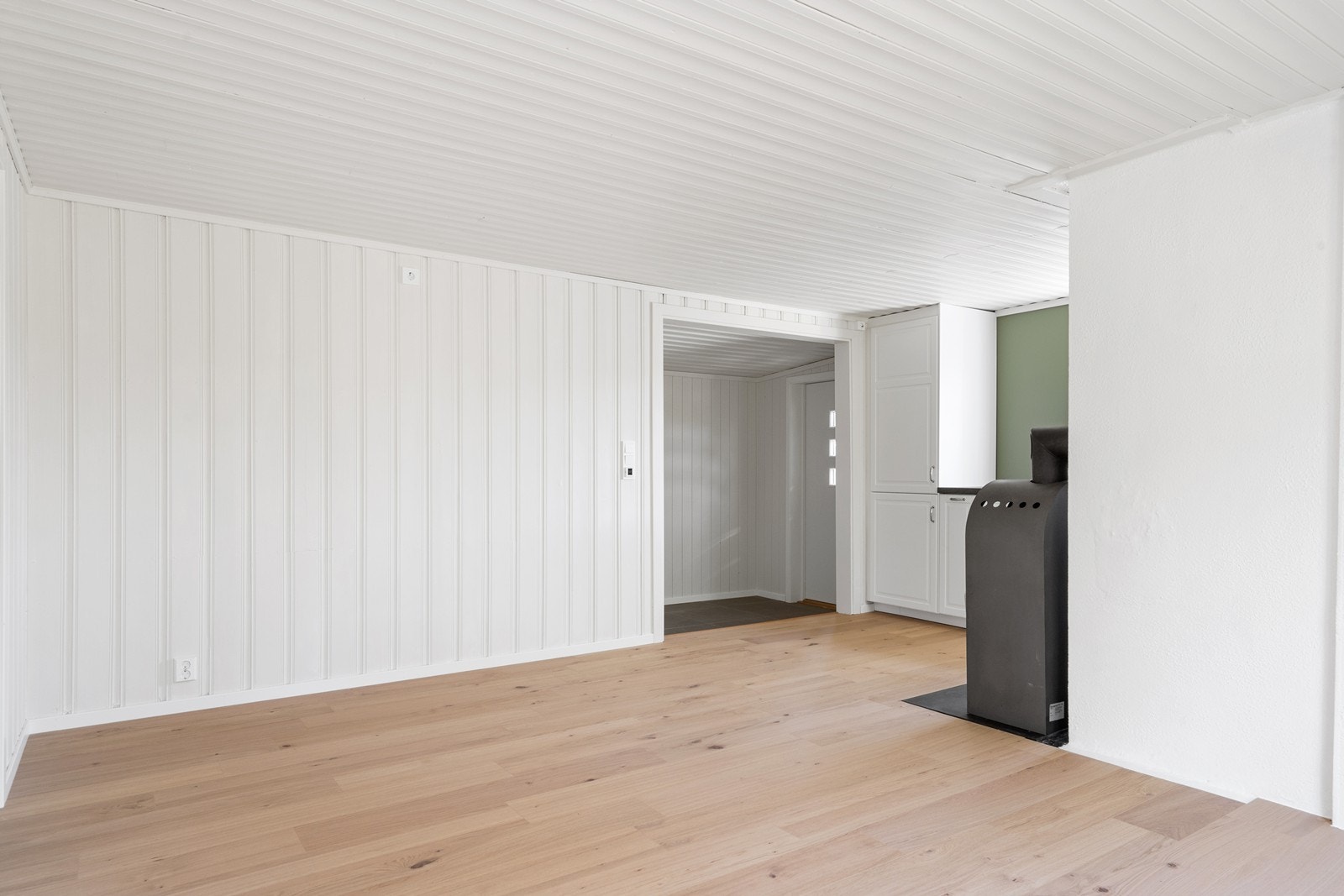 Parkett og lyse, malte panelvegger skaper en helhetlig og moderne stil. Galleribilde