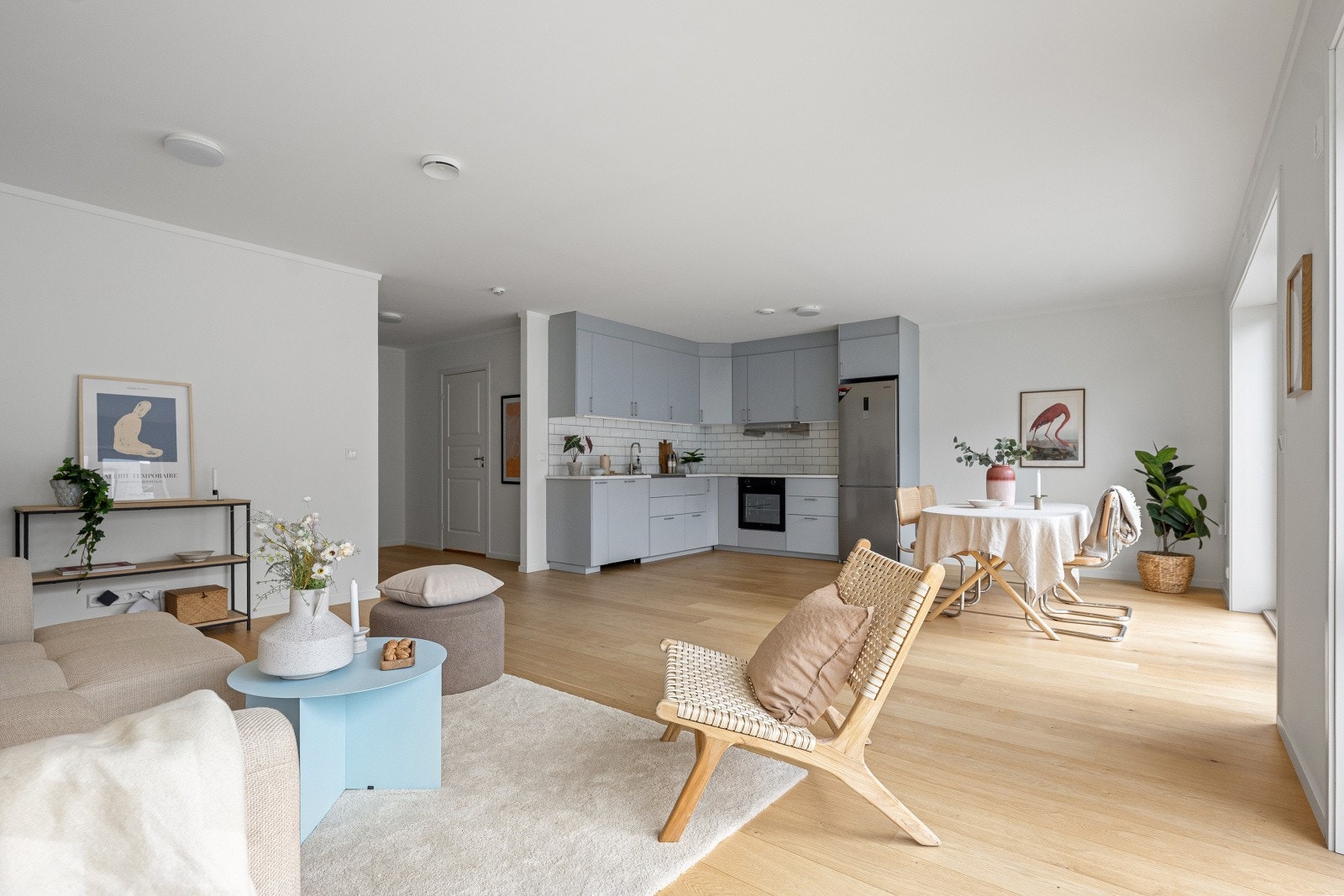 Den åpne stue- og kjøkkenløsningen inviterer til sosiale og hyggelige måltider med familie og venner. (Bildet er tatt fra tilsvarende bolig (speilvendt) i sameiet, noe mindre avvik kan forekomme) Galleribilde