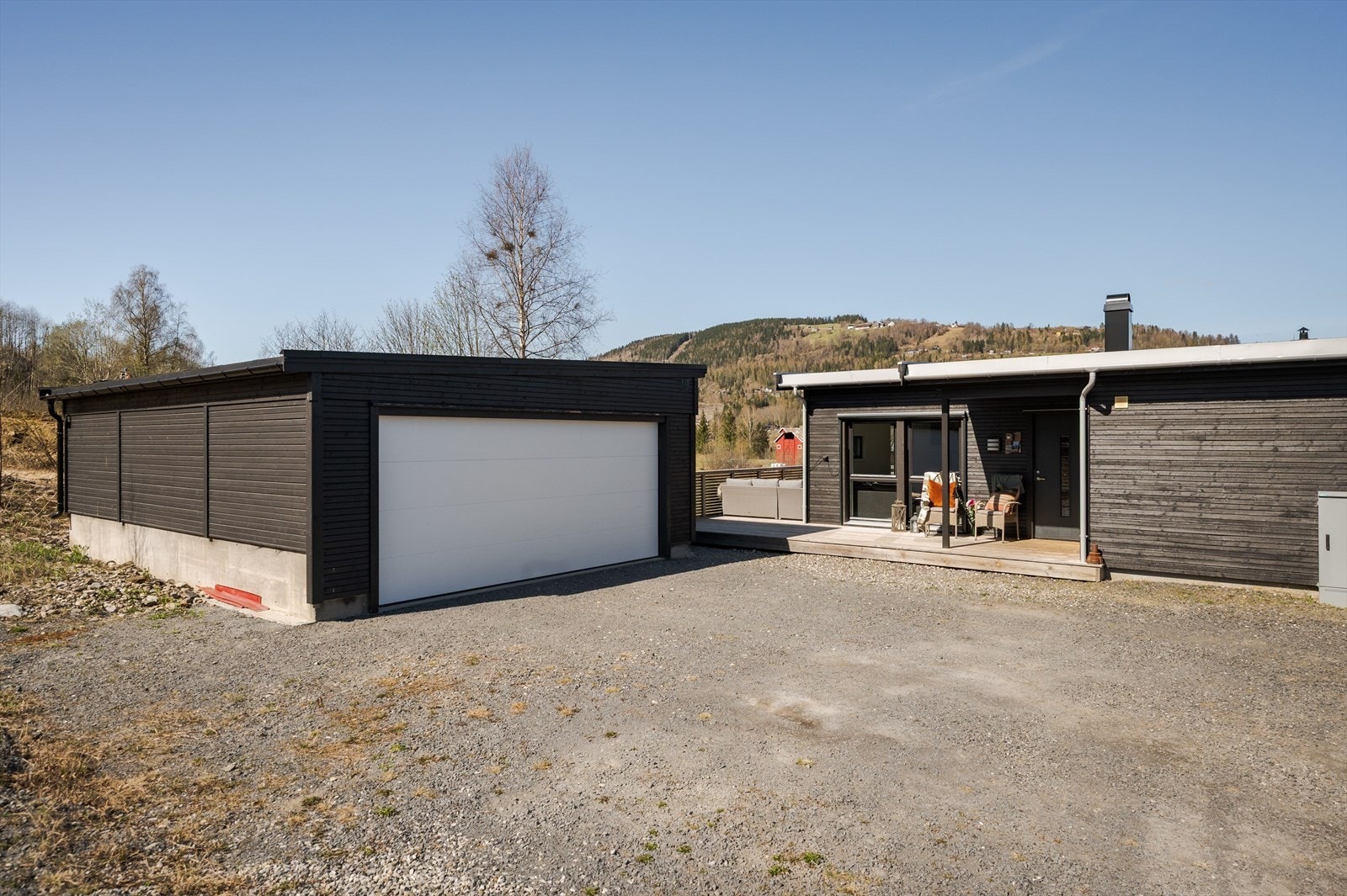 Dobbelgarasje og gruset gårdsplass. Galleribilde