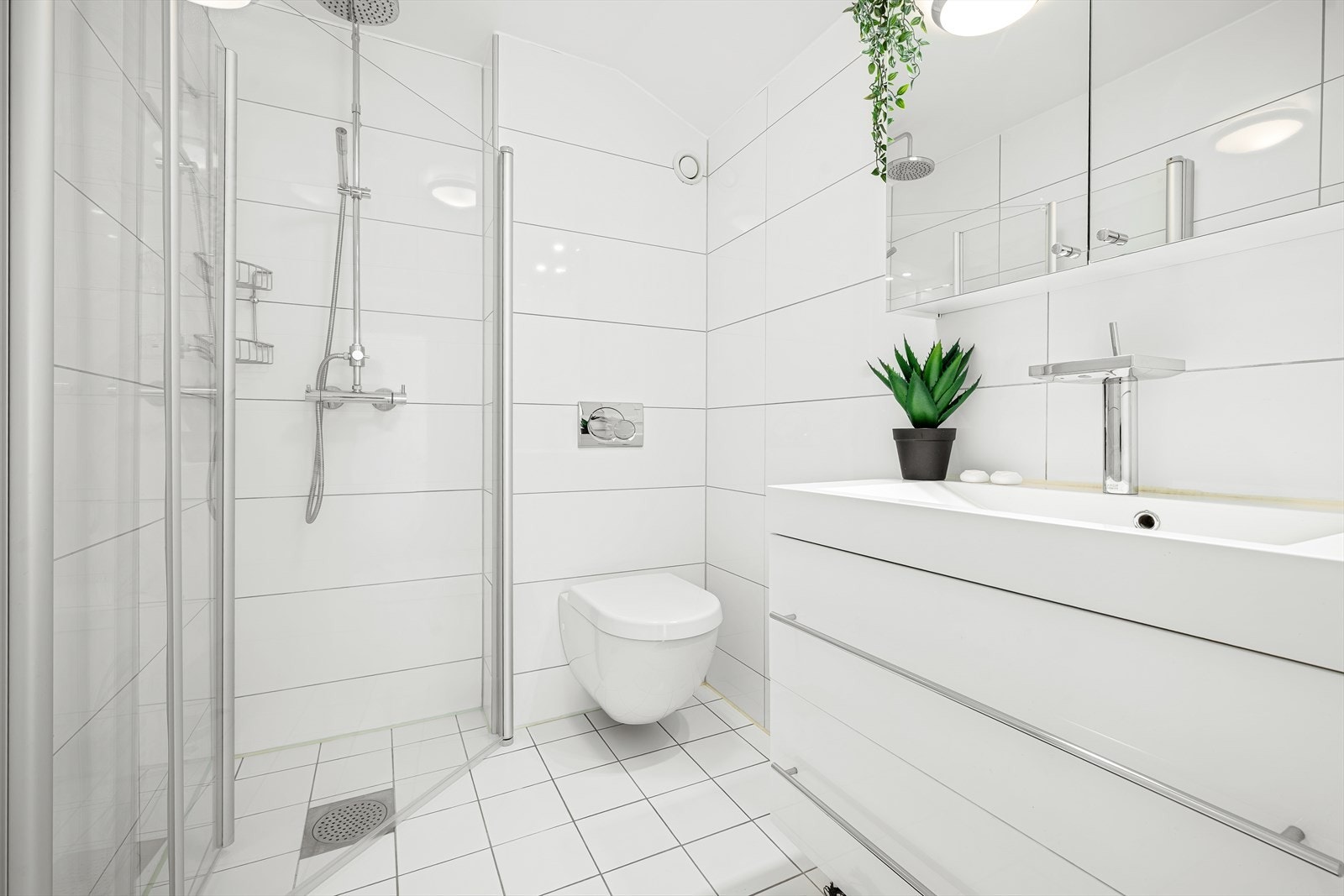 Badet i 2. etasje har flislagte vegger og gulv med elektriske varmekabler, samt innredning med nedfelt servant og veggmontert toalett. Galleribilde