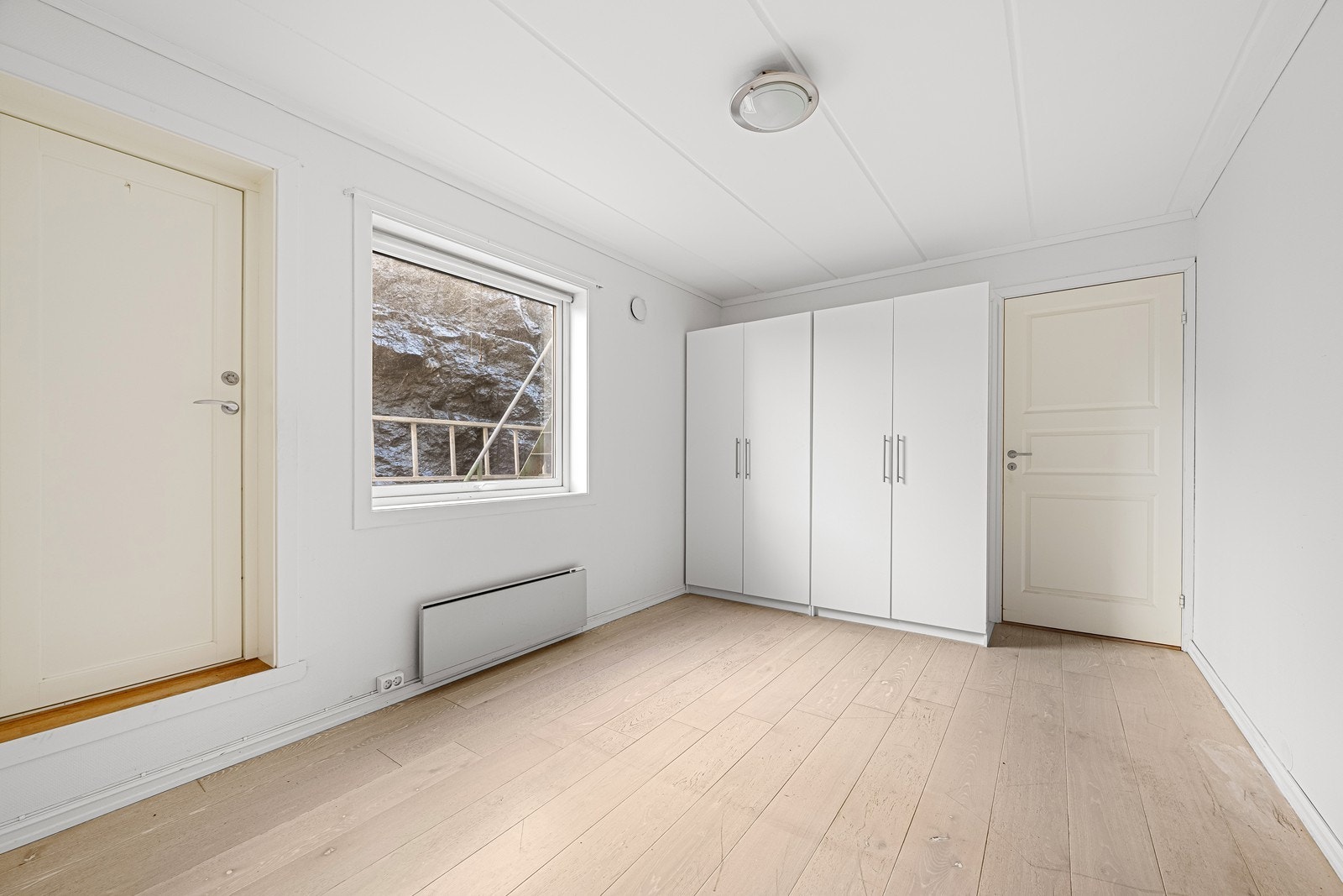 Stort og lyst soverom med 2 doble klesskap og utgang til uteplassen på baksiden av bygget. Galleribilde