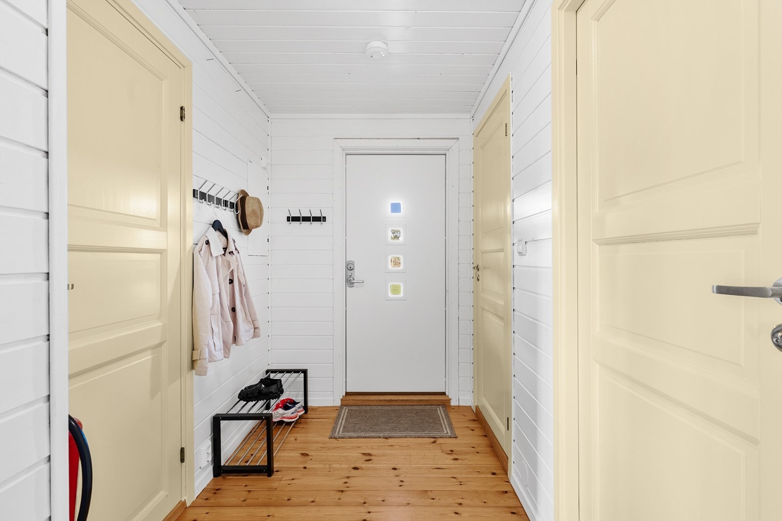 Gangen har furugulv og lyse panelvegger, som er gjennomgående i store deler av hytta. Galleribilde
