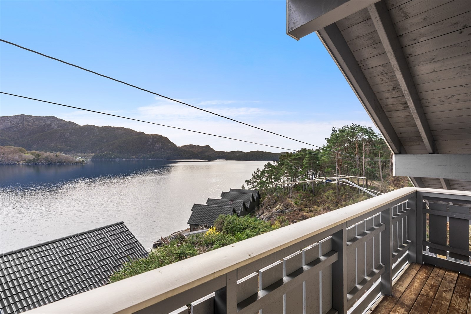 Fra balkongen i andre etasje ser man utover nærområdet og sjøen. Galleribilde
