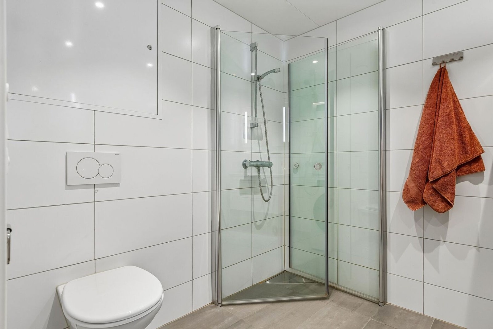 Badet er utstyrt med servantskap, vegghengt klosett, opplegg for vaskemaskin, rørskap og innfellbare dusjvegger. Galleribilde