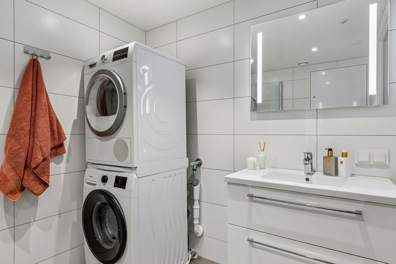Flislagt og lyst baderom på 5 kvadratmeter, med downlights i himling og opplegg samt plass til både vaskemaskin og tørketrommel. Galleribilde