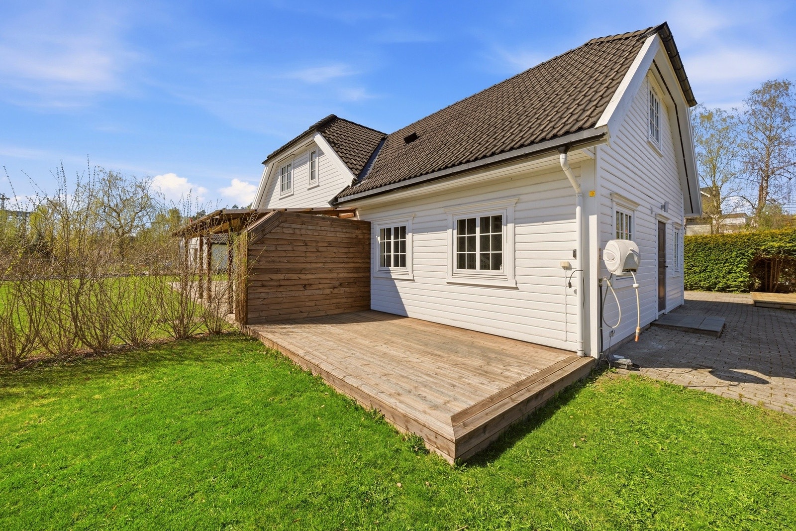 Solrik og innbydende terrasse med god plass til utemøbler - perfekt for avslappende dager og hyggelige sommerkvelder. Galleribilde