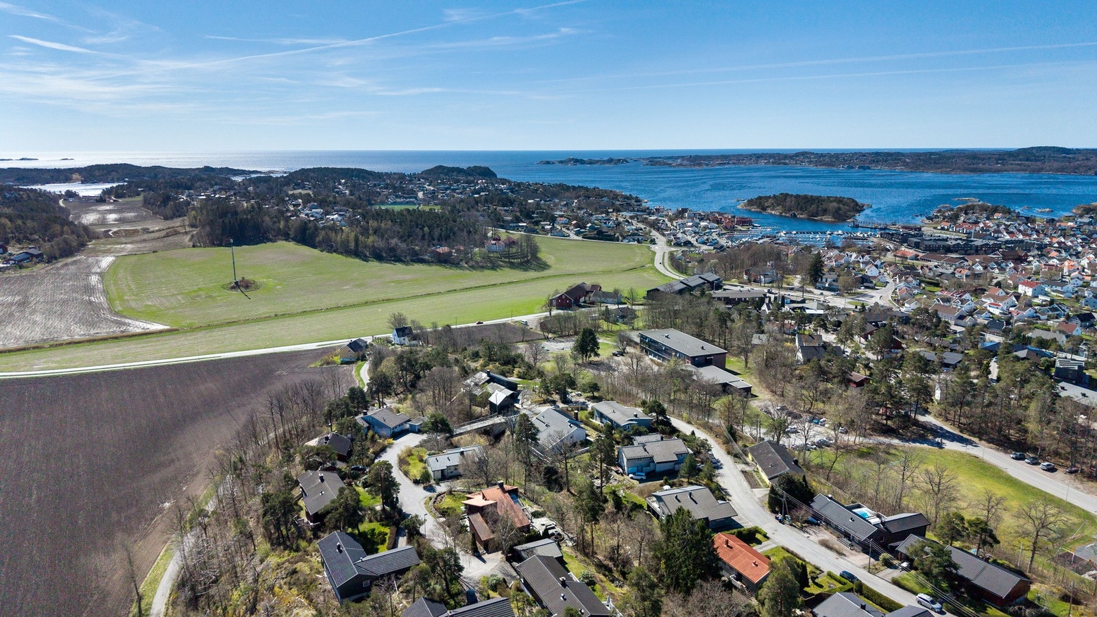 Oversiktsbilde som viser et boligområde med nærhet til sjøen og landlige omgivelser. Galleribilde