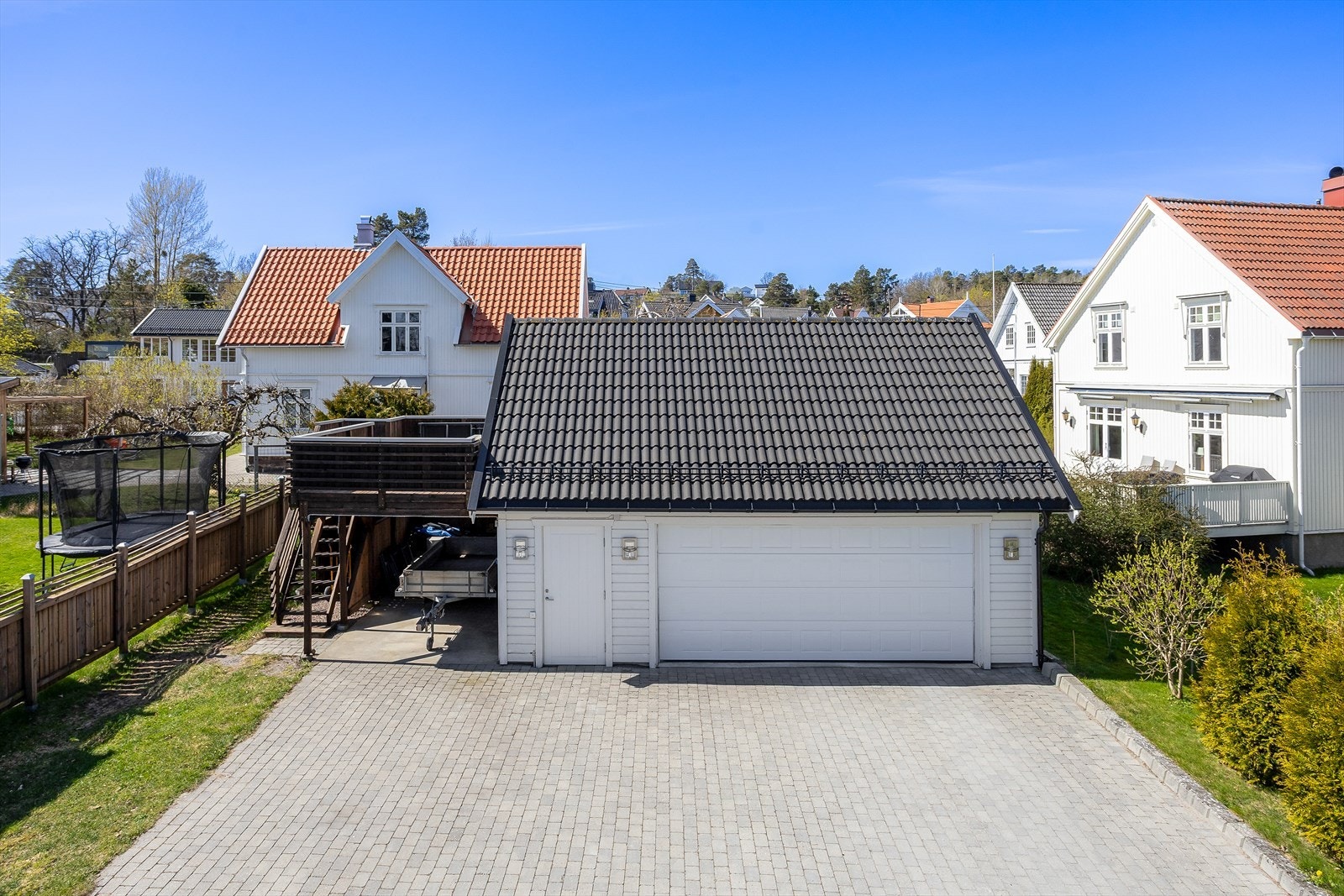 Stor dobbelgarasje med carport, motorisert leddport, soldekk og et romslig lagringsloft Galleribilde