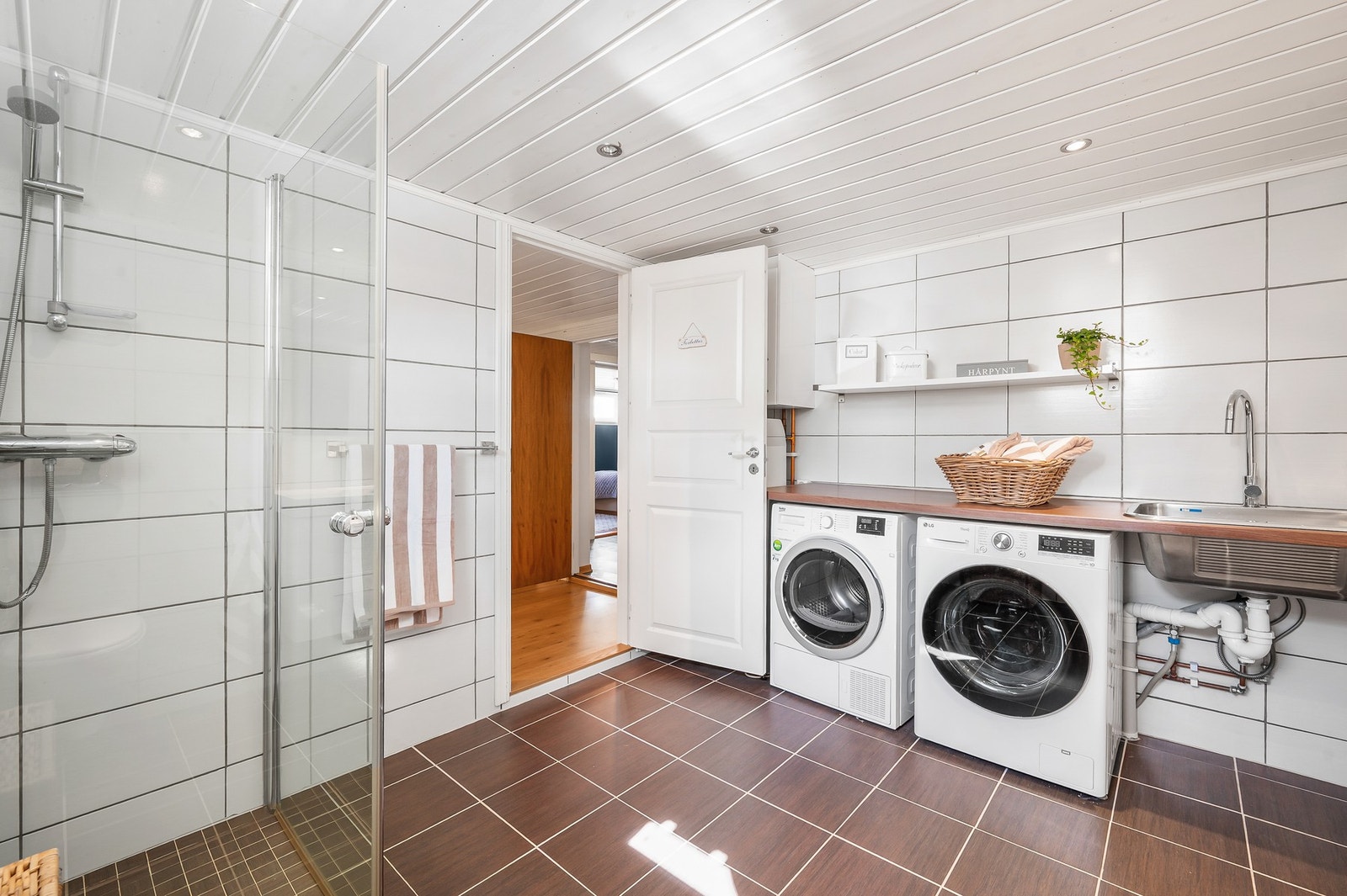 Flislagt bad fra 2011 med gulvvarme, flislagte vegger og malt himling. Dusjhjørne med glassdører og vegghengt toalett. Galleribilde