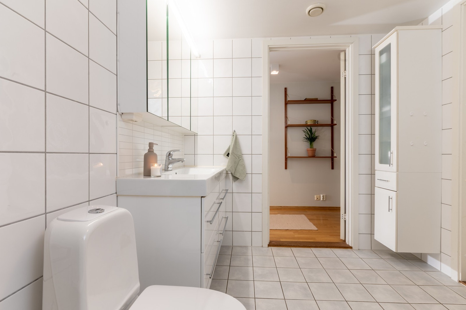 Flislagt hovedbad som er utstyrt med varmekabler, toalett og badekar. Her er det også opplegg for vaskemaskin og tørketrommel Galleribilde