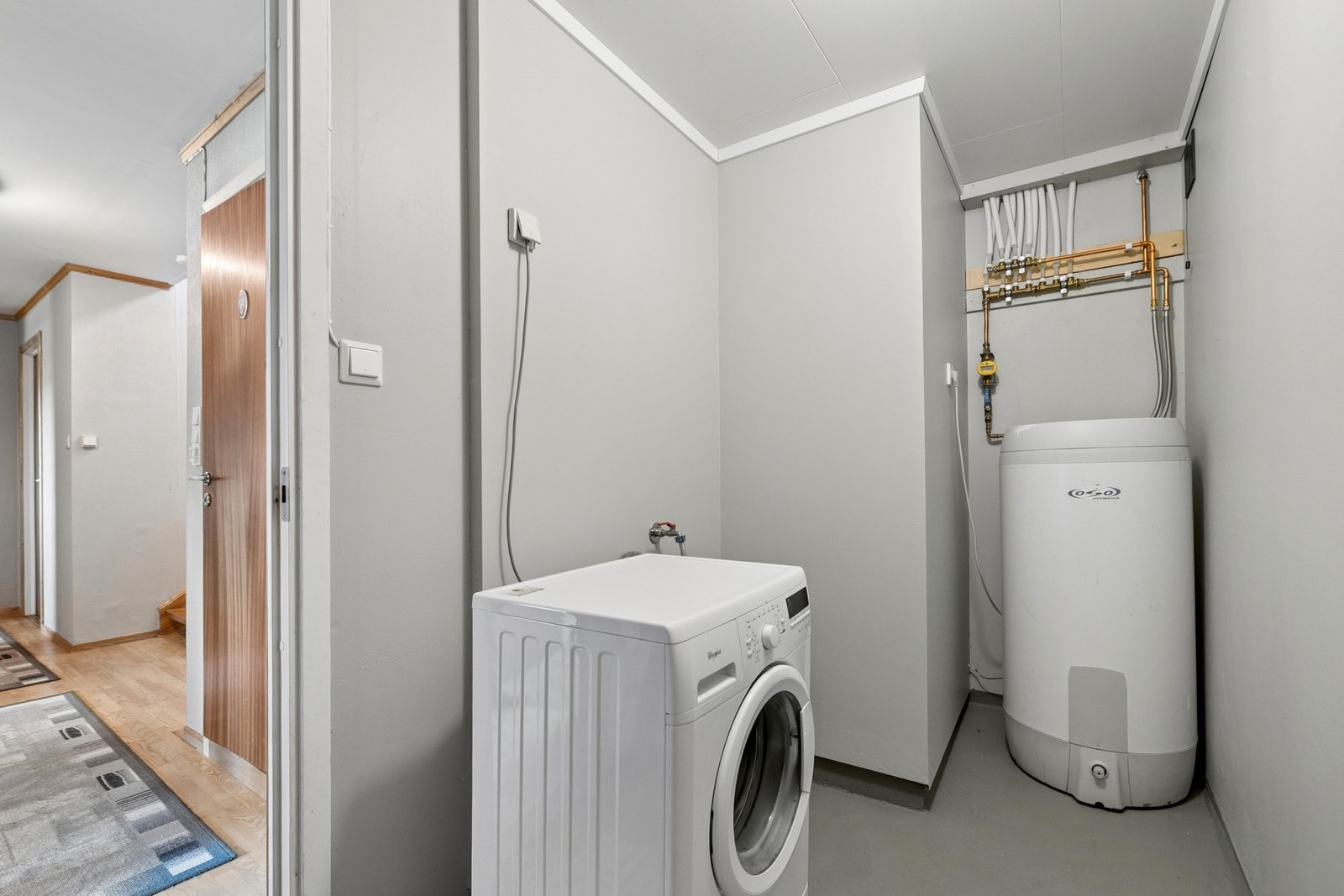 Praktisk vaskerom med opplegg for vaskemaskin i boligens underetasje. Galleribilde