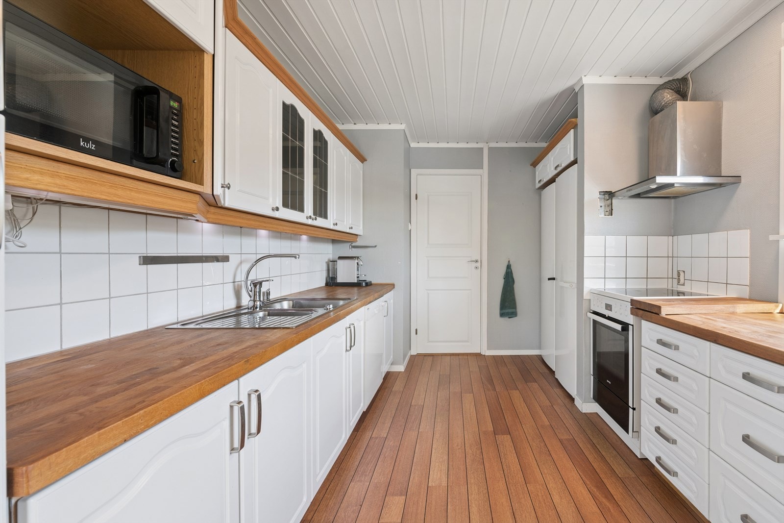 Kjøkkenet har en velholdt innredning med profilerte fronter og benkeplate i heltre. Galleribilde