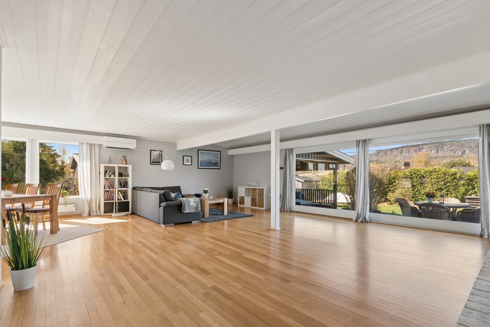 Stuen preges av store vindusflater som slipper rikelig med dagslys inn og skaper en lys og luftig atmosfære. Vinduene rammer inn naturens farger noe som gir en behagelig og levende romfølelse gjennom hele året. Galleribilde