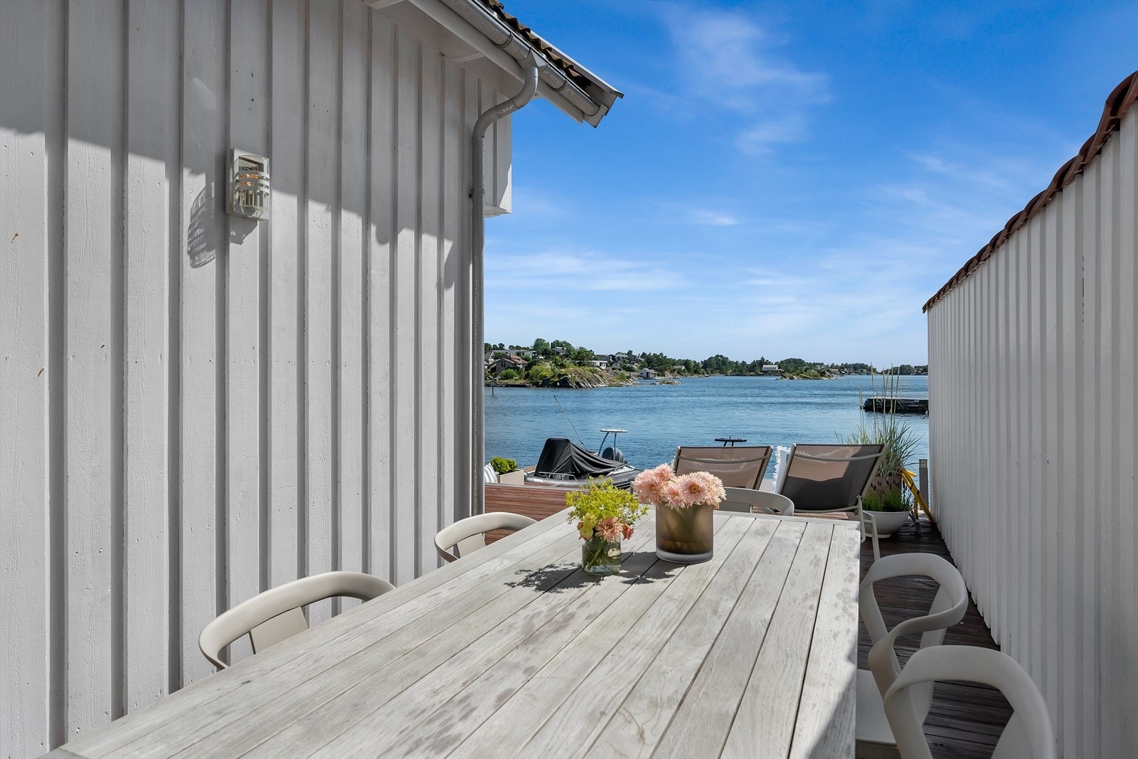 Det er plass til et spisebord her med flott utsikt til brygge og sjø Galleribilde