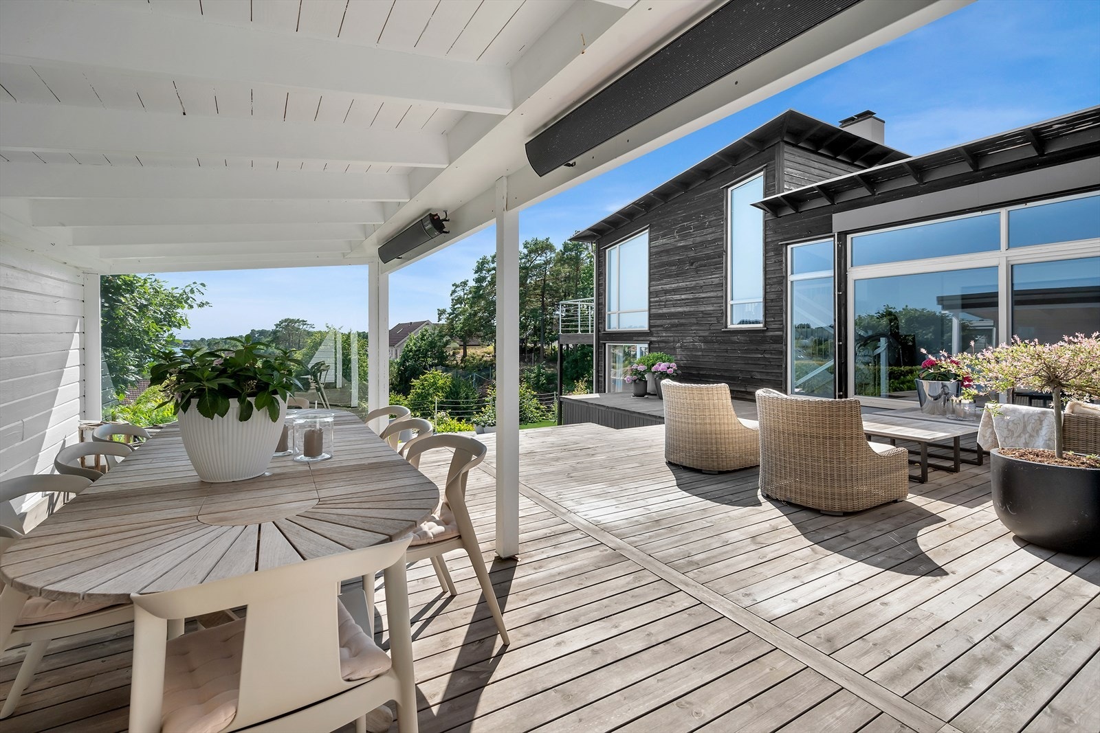 Stor terrasse med utestue hvor det er plass til spisebord, sittegruppe og annet tilhørende møblement - perfekt for lange sommerkvelder Galleribilde