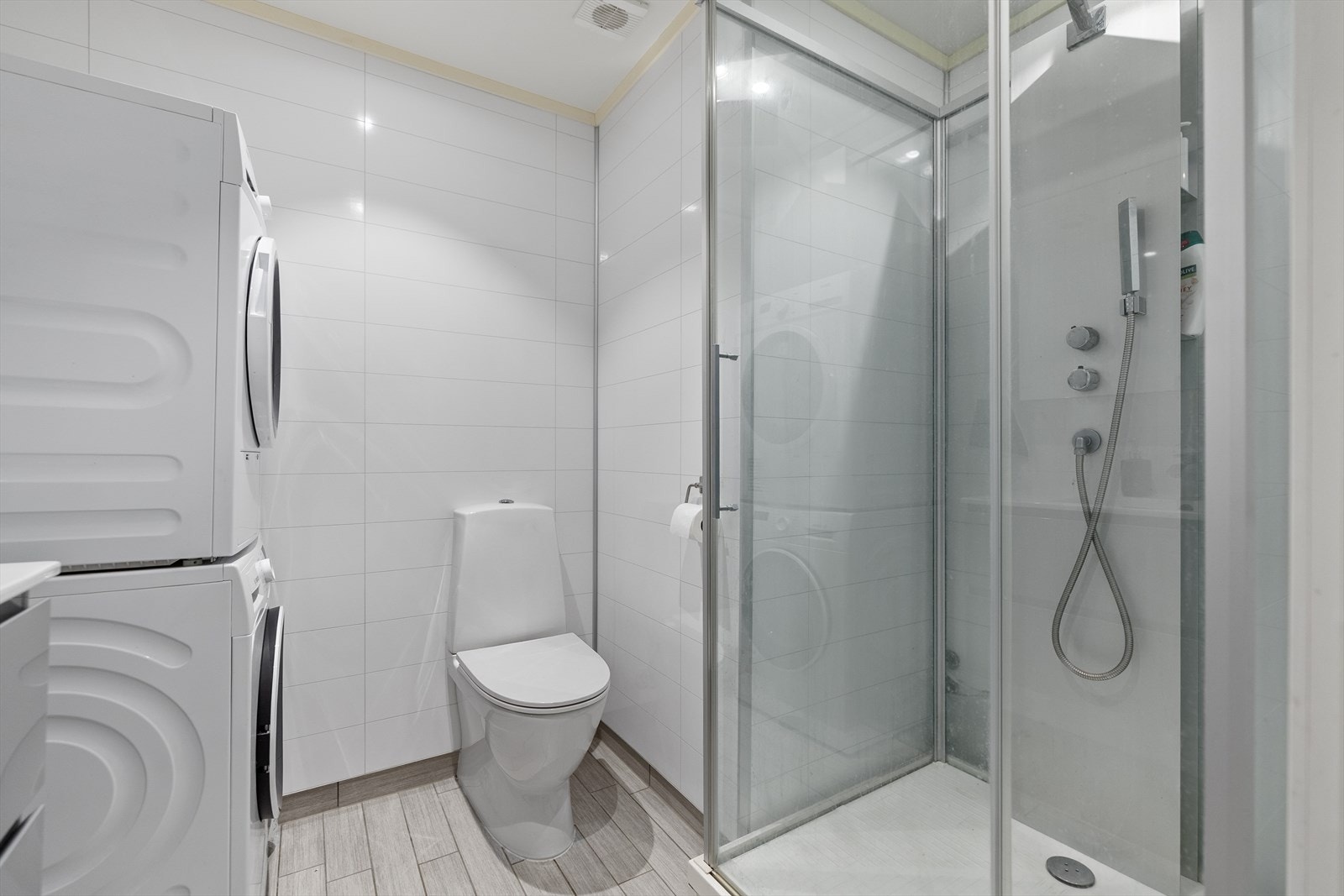 Badet inneholder innredning med nedfelt servant, vegghengt speilskap, gulvmontert toalett, dusjkabinett samt opplegg for både vaskemaskin og tørketrommel. Galleribilde