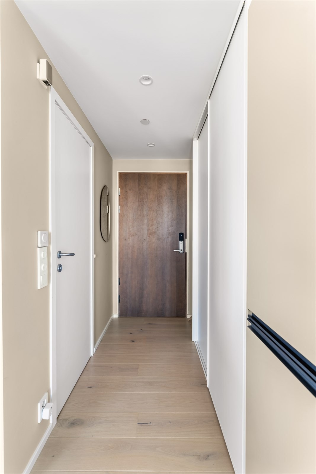 Lys og innbydende entré som gir et elegant førsteinntrykk av boligen. I entréen har du en romslig skyvedørsgarderobe og praktisk adgang til et av leilighetens to bad. Galleribilde