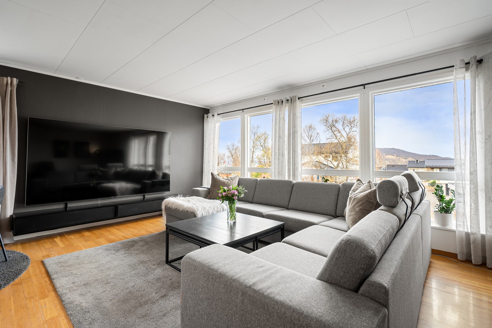 Lys og romslig stue med flotte vindusflater Galleribilde