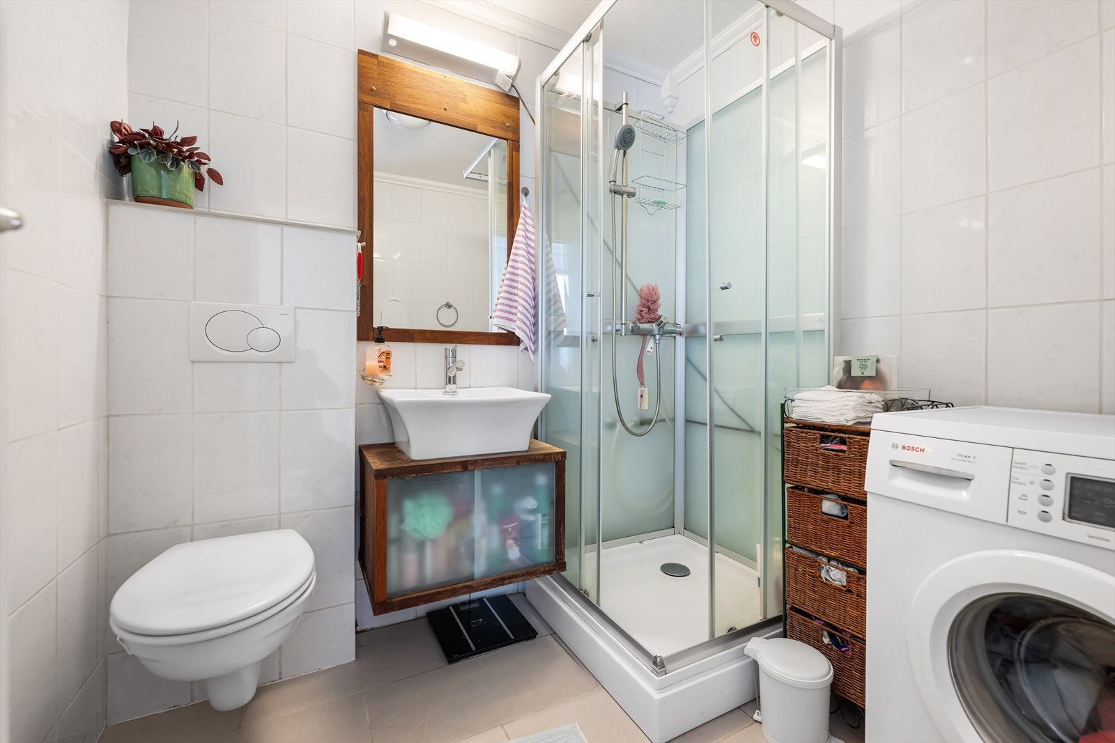 Badet er helfliset og godt utnyttet. Her er det blitt plass for både dusjkabinett, vegghengt toalett, baderomsinnredning og vaskemaskin. Galleribilde