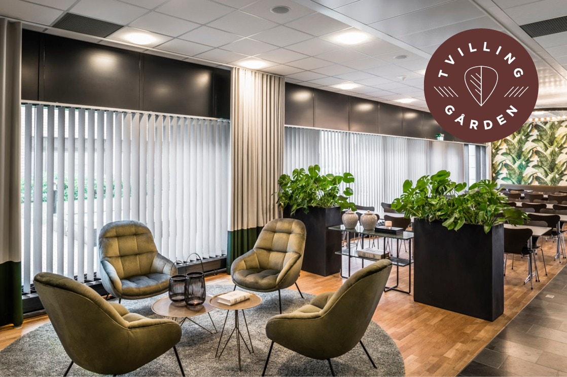 Moderne og innbydende fellesareal med komfortable sitteplasser og frodig planteinnredning. Ideal for sosiale sammenkomster. Galleribilde