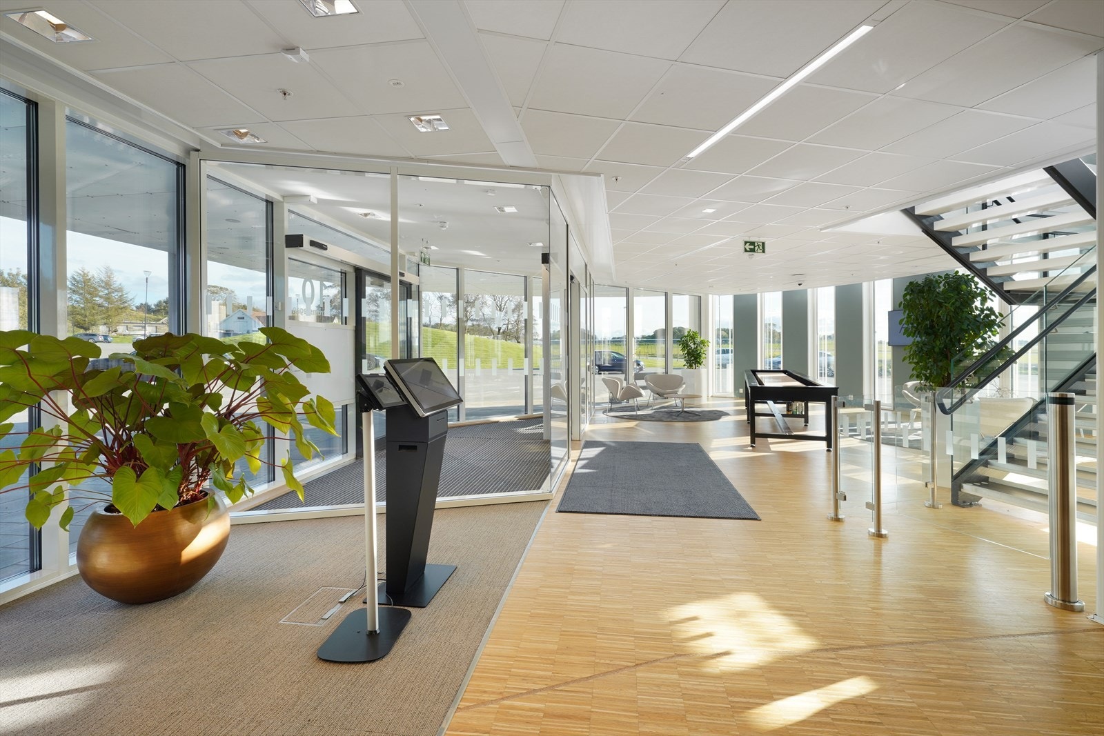 Lys og moderne entré med store vinduer og elegant trapp. Innbydende atmosfære perfekt for representasjon og velkomst. Galleribilde