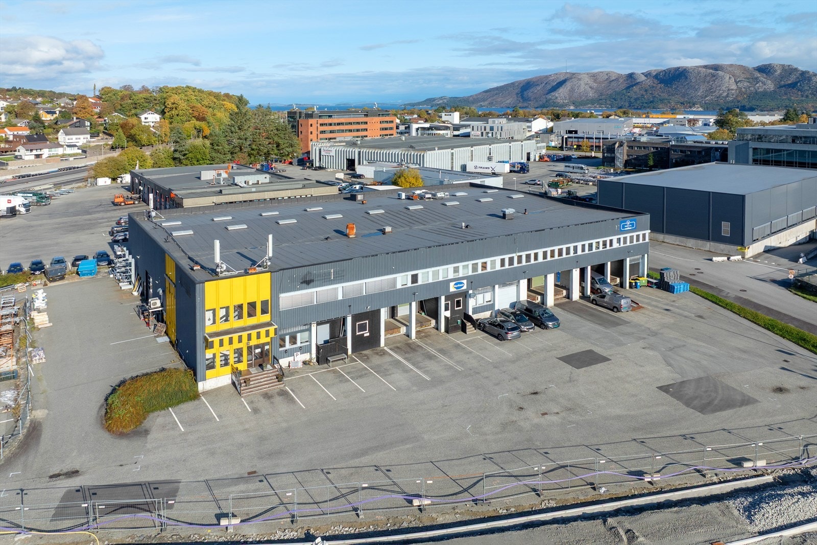 Næringsbygg med flott beliggenhet. Romslig parkeringsplass og nærhet til naturskjønne omgivelser, perfekt for bedrifter som ønsker synlighet. Galleribilde