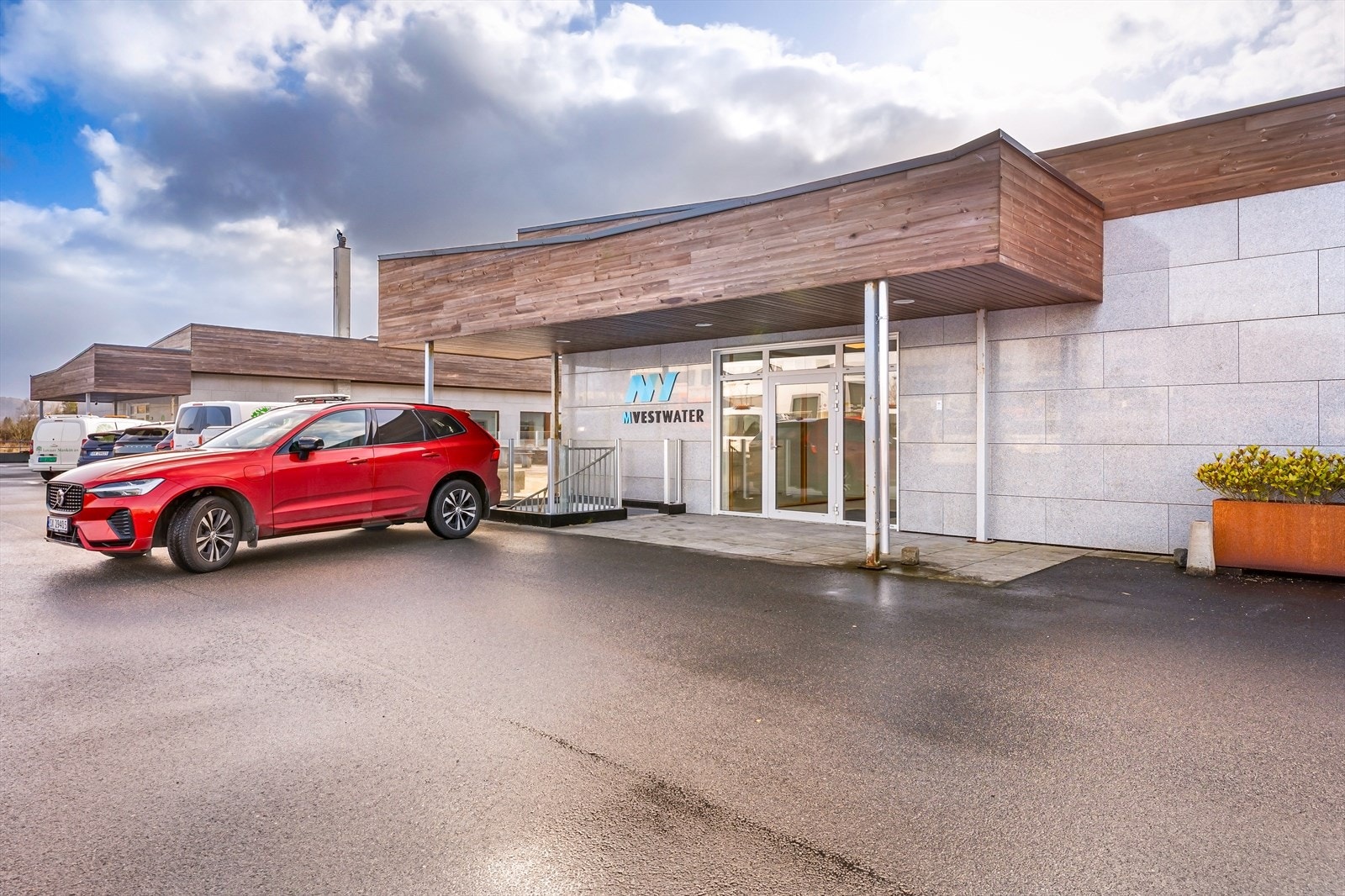 Inngangsparti til kontorlokalene med parkering rett utenfor inngangen.