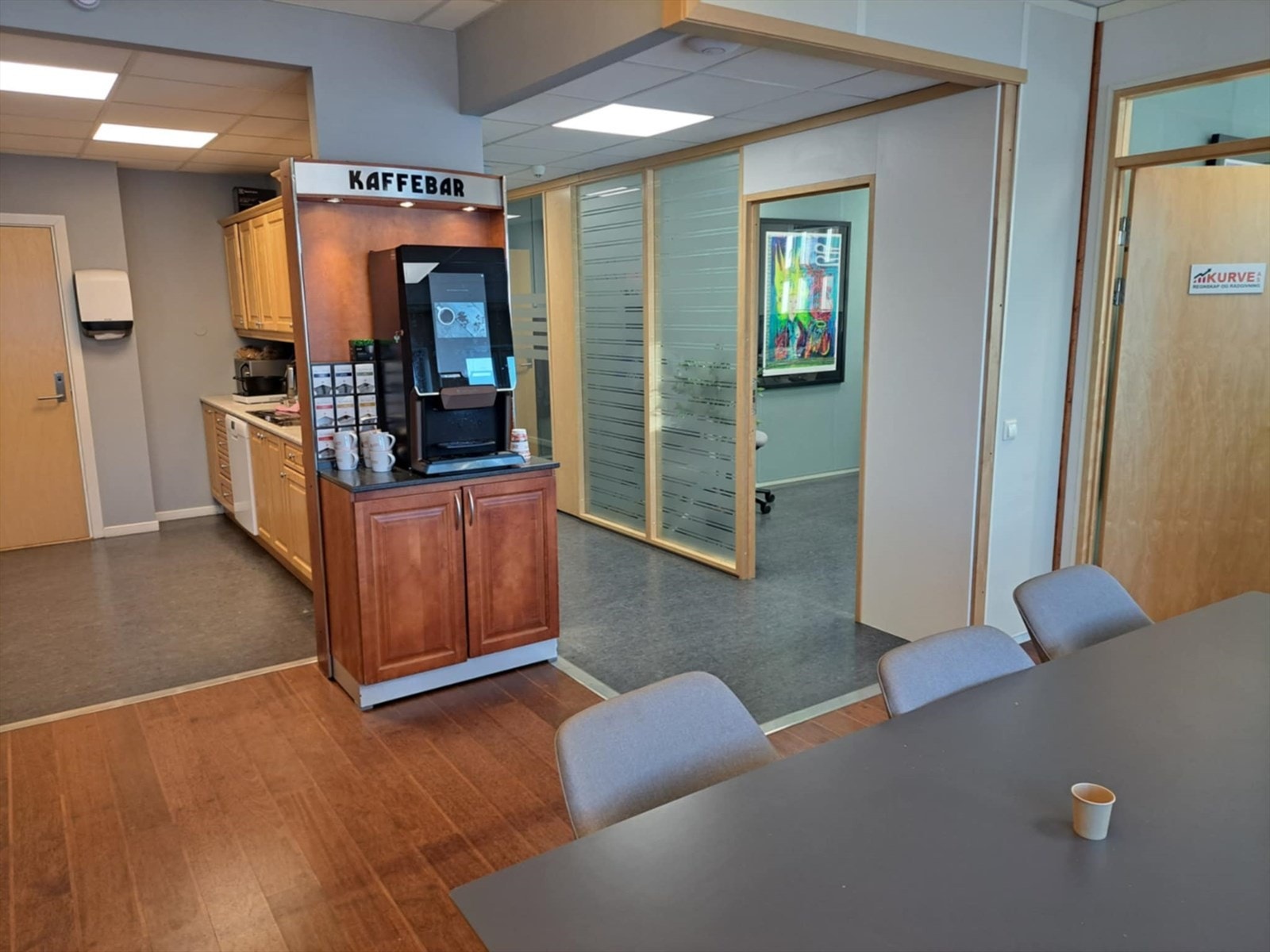 Felles kjøkken med moderne kaffemaskin og spiseareal Galleribilde