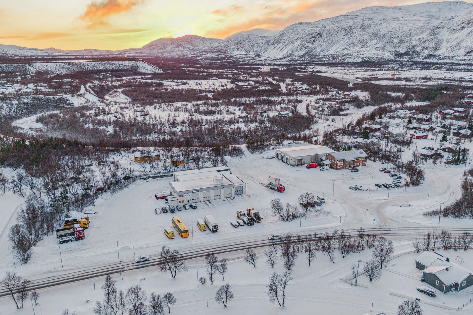 Drone av området. Området er spredt boligbebyggelse og i bakgrunnen er kjente Lakselva. Galleribilde