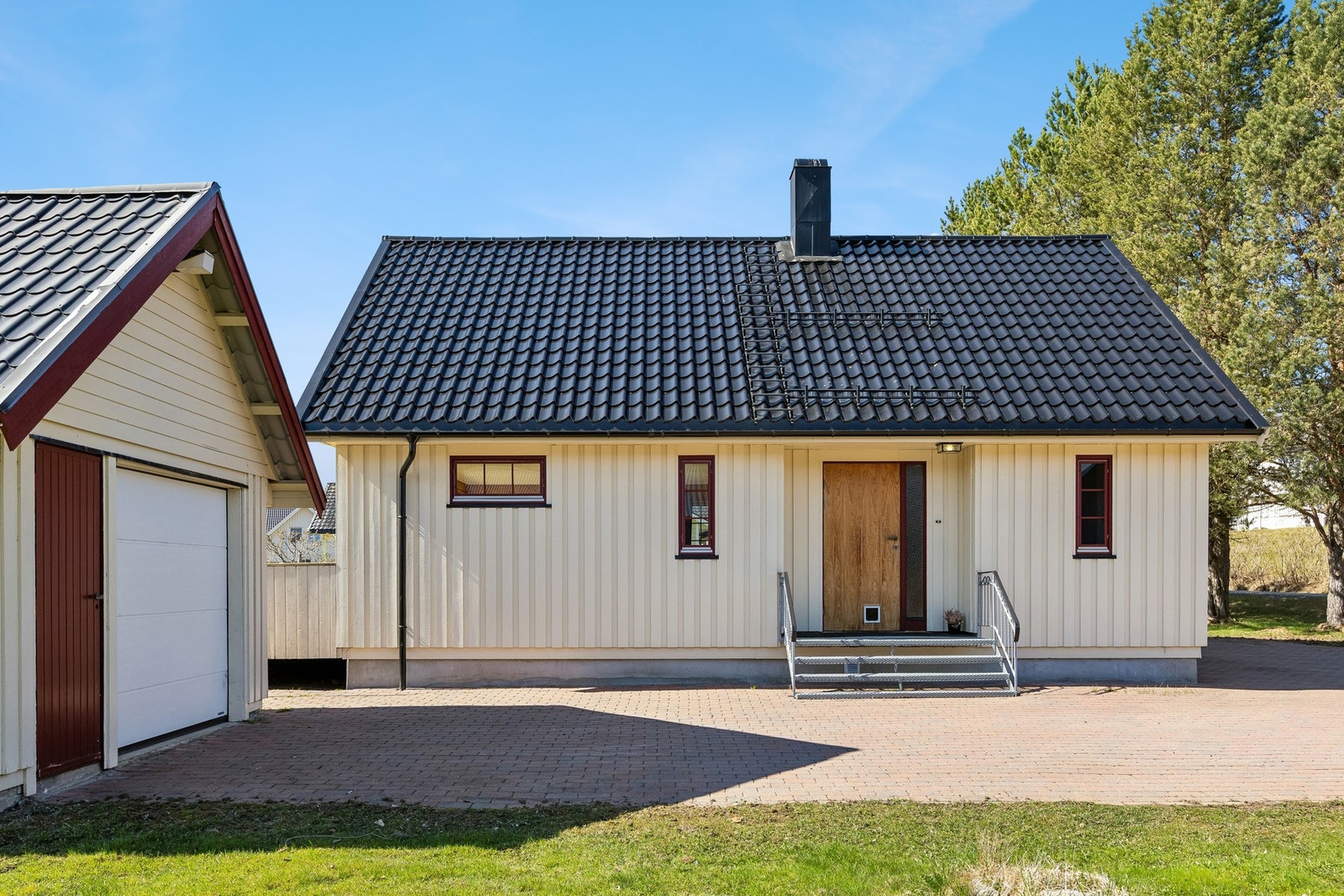 Pen steinlagt gårdsplass og praktisk garasje. Galleribilde