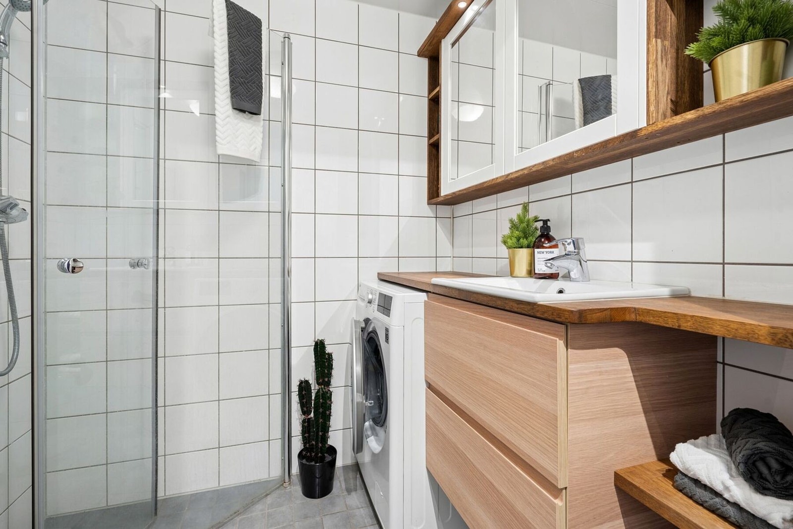Stilrent og tidløst bad med fliser på gulv og vegger og moderne fasiliteter. Galleribilde