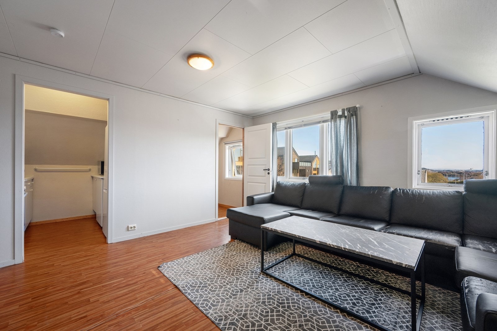 En delvis åpen stue/kjøkken løsning hvor det er plass til både sofa- og spisegruppe. Galleribilde