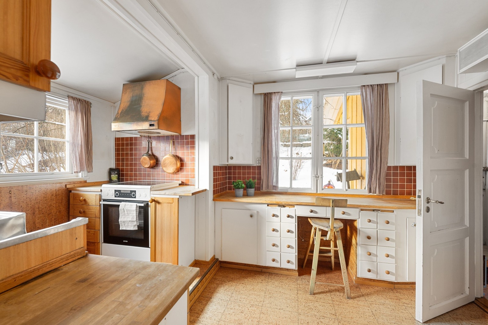 Kjøkken med profilerte fronter og heltre benkeplate, samt integrert arbeidsplass ved vinduet med utsikt mot hagen. Rommet har en funksjonell planløsning og gode muligheter for modernisering etter eget ønske. Galleribilde