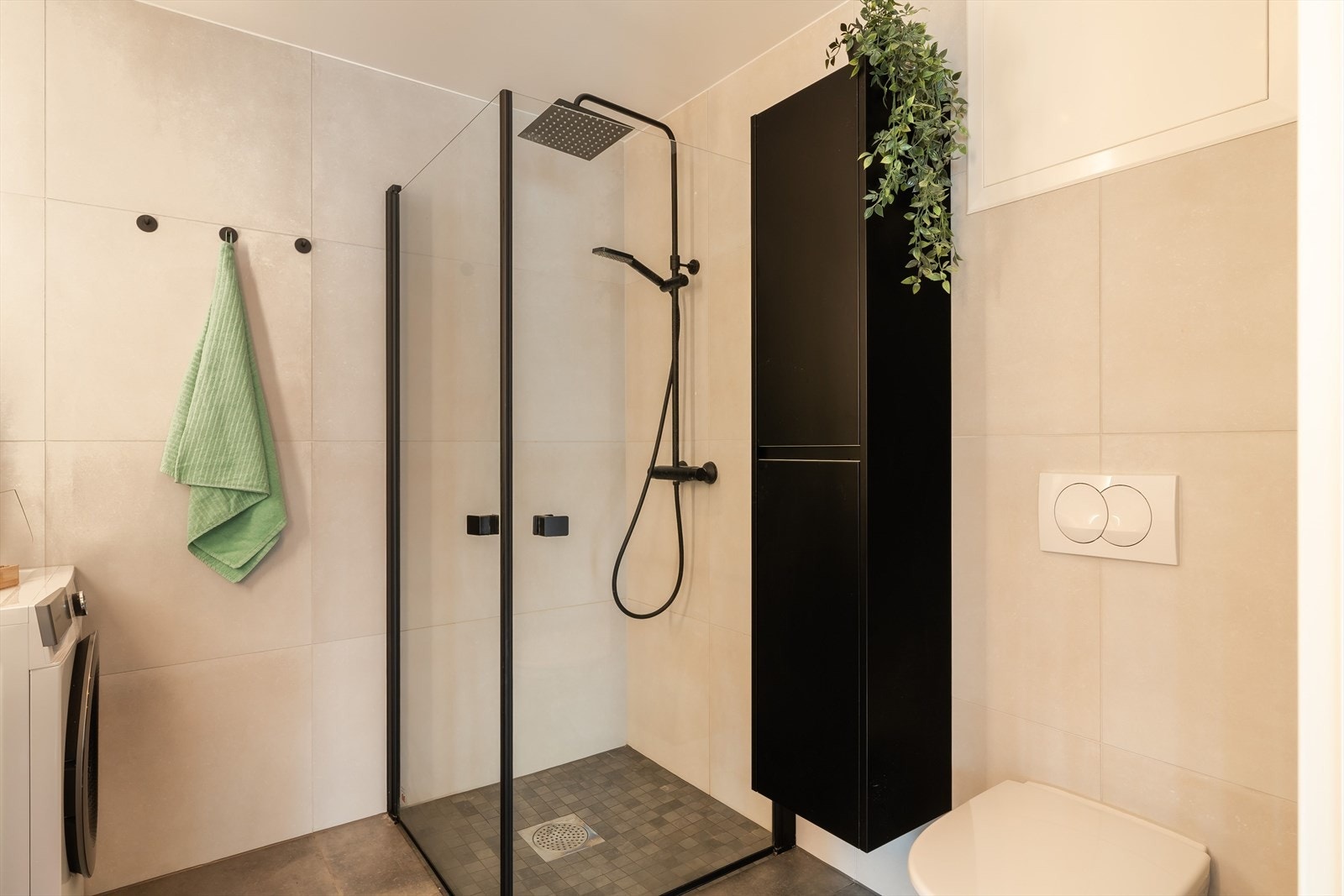 Badet er utstyrt med dusjhjørne, vegghengt toalett, servant med underskap og speil. Galleribilde